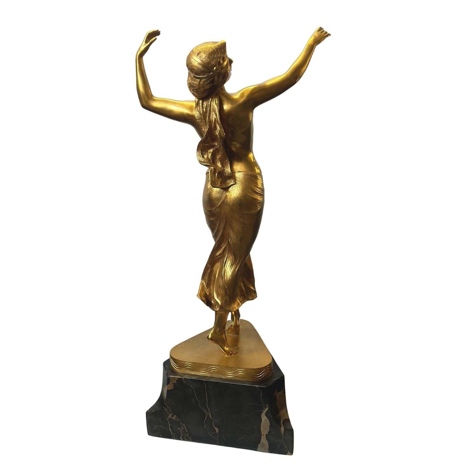 Alluring sculpture by the distinguished German artist featuring an oriental dancer woman dancing gracefully on a black Portero marble triangle base. It captures the dancer's mesmerizing movements as she gracefully stands on her tippy toes, embodying