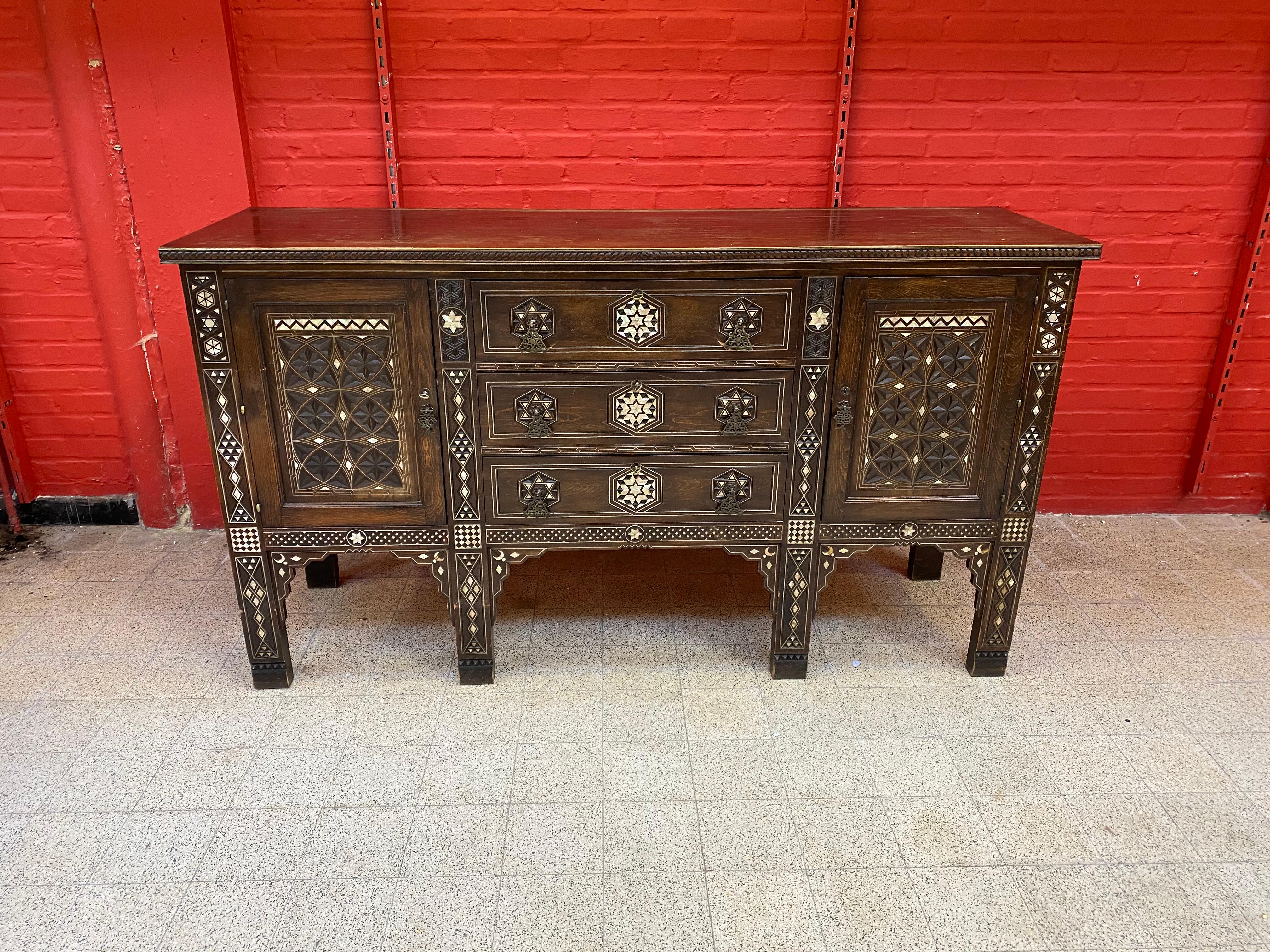 Large oriental-style sideboard in carved wood, with mother-of-pearl inlay; wrought iron handles;
pewter wire inlay 
small losses of mother-of-pearl.
Provenance the Old Palace Saint George in Alger, circa 1880.
is part of a complete dining room.