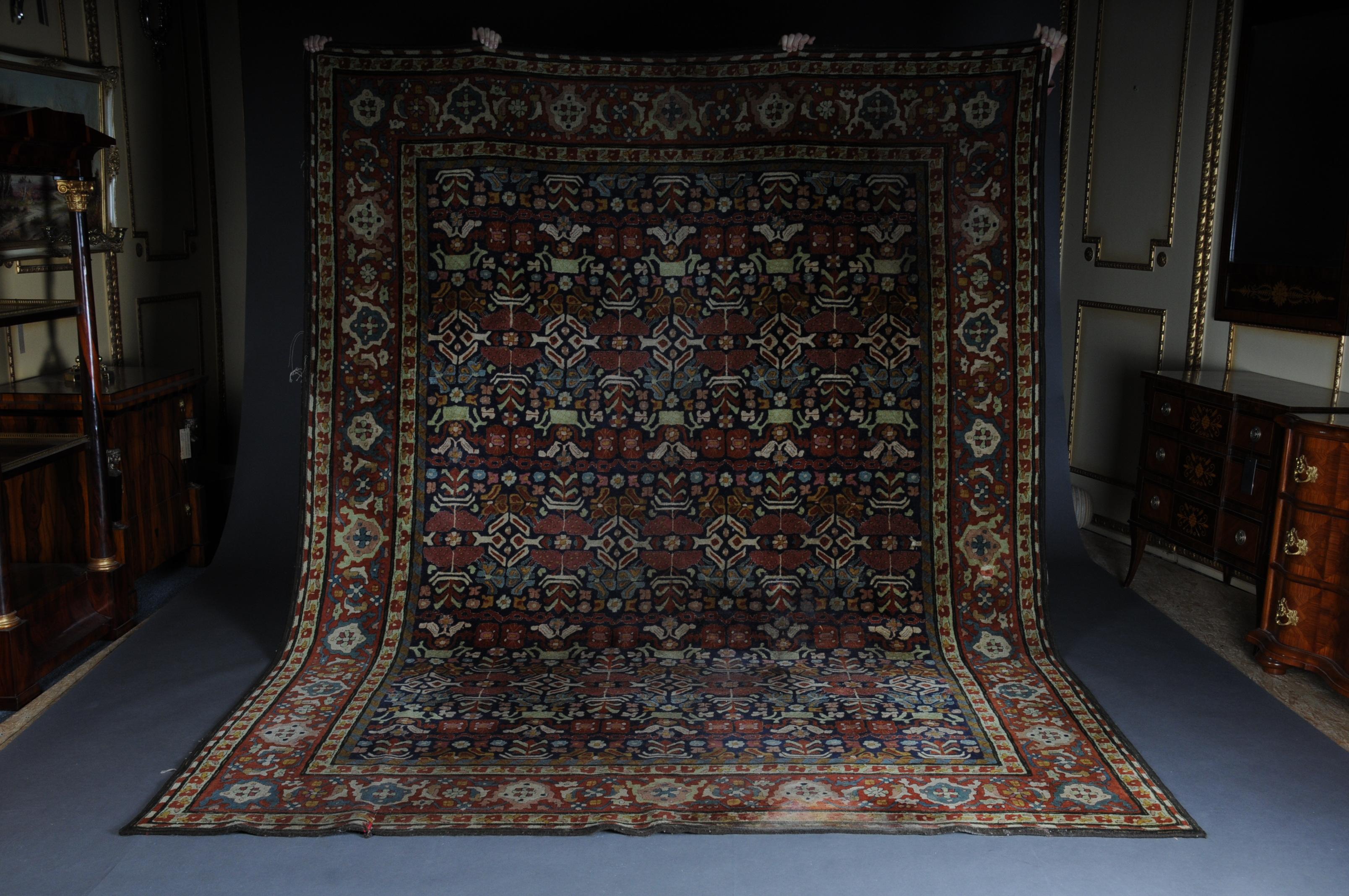 Large oriental Tefzet carpet, circa 1920. Measures: 250 x 340 cm

Wool on cotton. In the red central field, a pattern covering large, different palmette motifs and rosettes of flowers, connected by narrow tendrils. All-round wide, red-ground