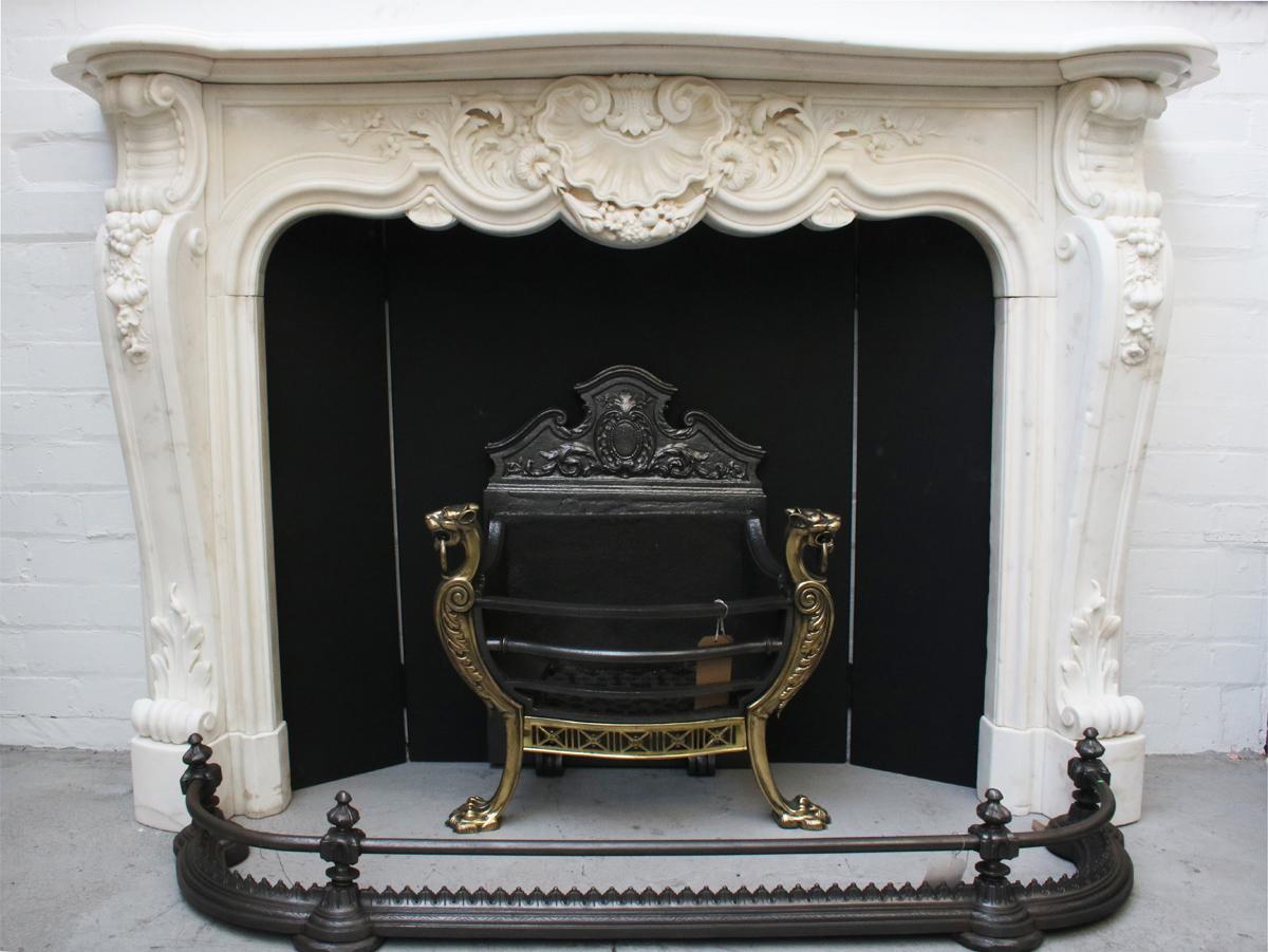 A large and very fine quality original 19th century Louis XV style fireplace surround in white statuary marble. The profusely carved frieze, protruding from beneath the mantle with large clam shell carved to the centre and a festoon of flowers and