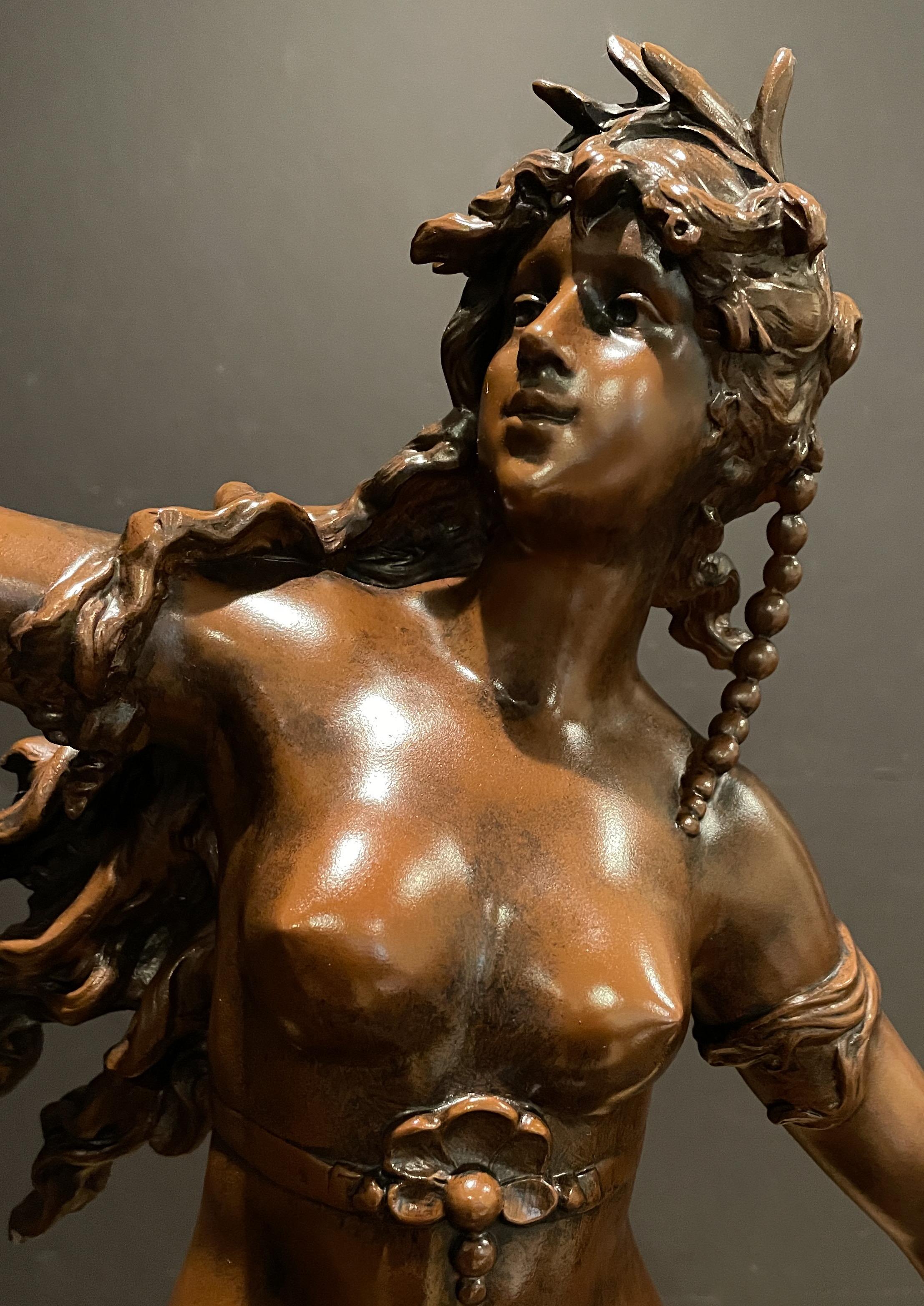 Grande sculpture française du XIXe siècle réalisée par L. et F. Moreau représentant une jeune fille tenant un bol de baies, assise sur des vagues en crête et un oiseau en vol. Fabriqué en spelter, ou métal en pot, avec une belle patine chaude et