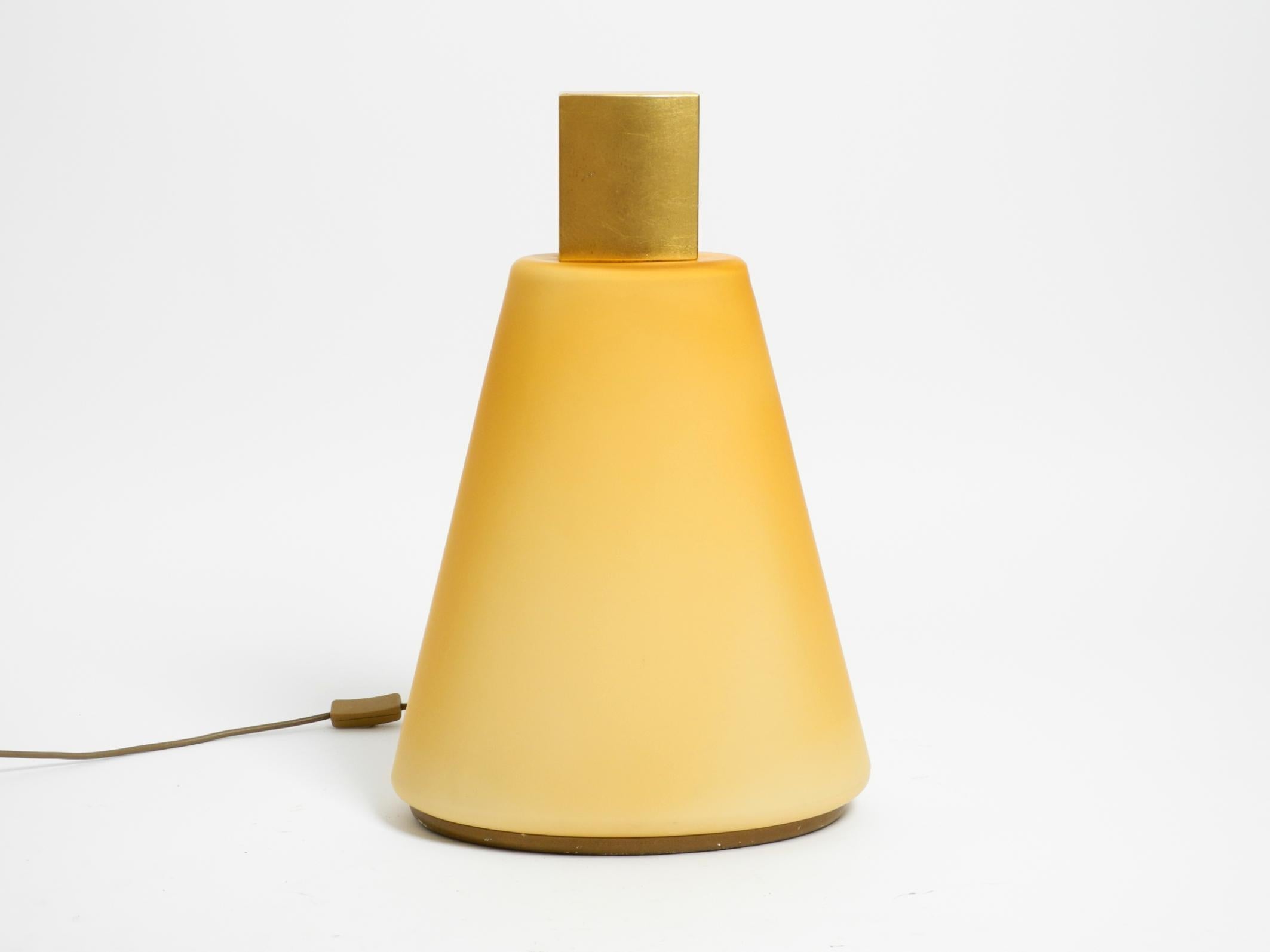 Beautiful, large, original 1990s Postmodern design floor or table lamp made of yellow-orange, apricot-colored flashed glass.
Great design in the shape of a flacon bottle. The top 