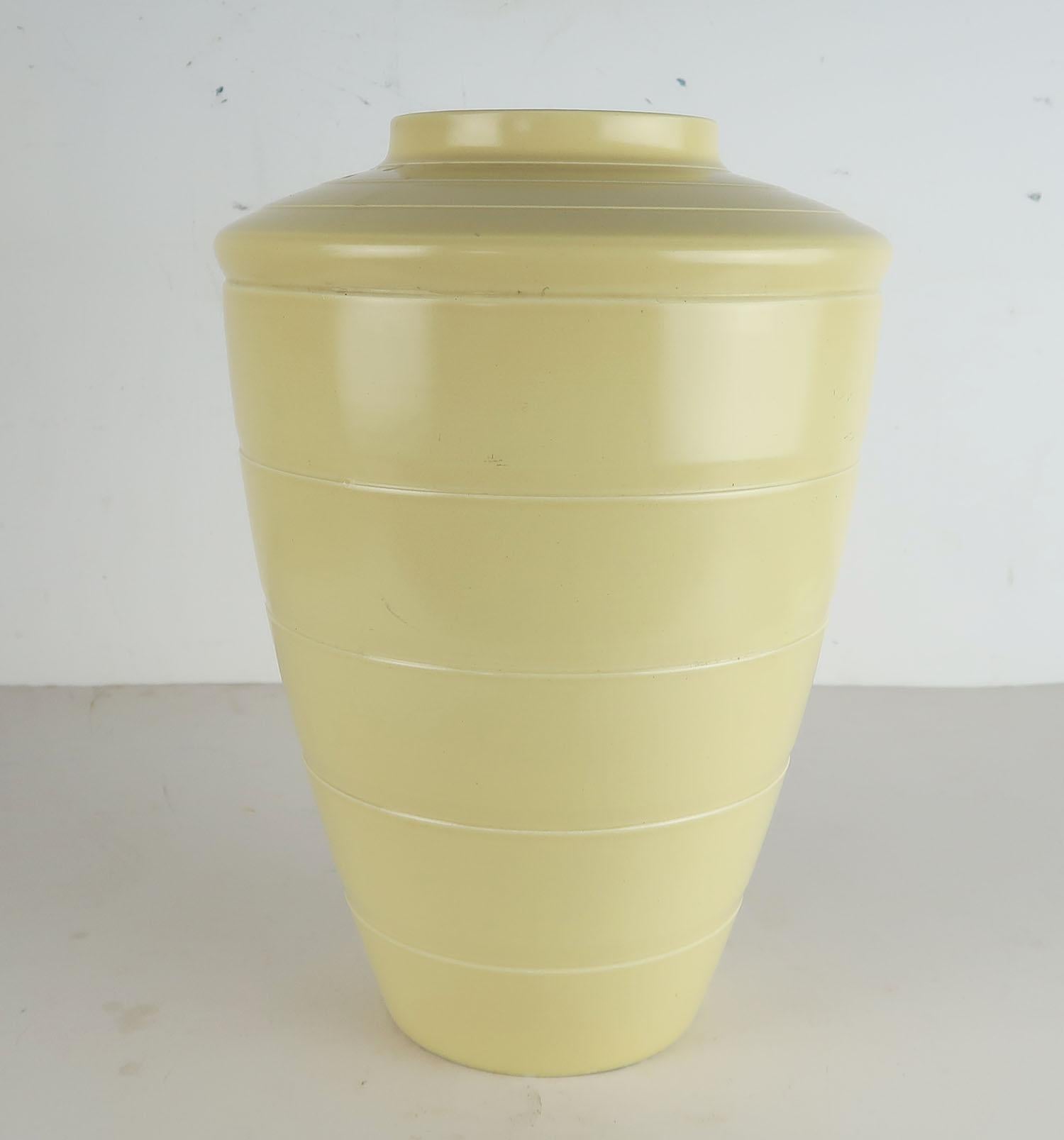 Joli vase de forme et de bonne taille en céramique crème/jaune pâle fabriqué par Wedgwood.

Conçu par Keith Murray

Marques de fabrique et signature en fac-similé sur la base

Petite imperfection sur le bord de la base.



