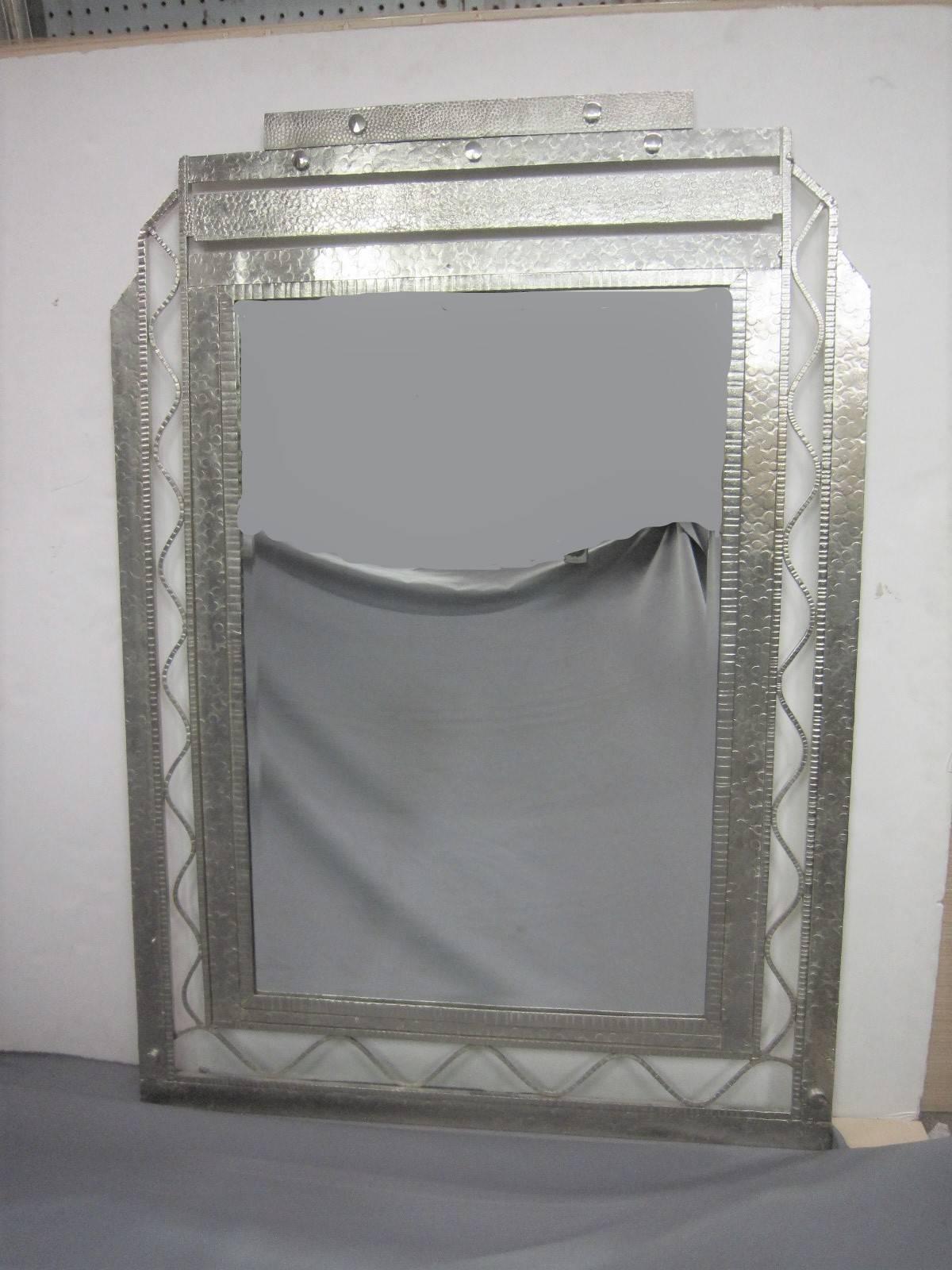 A very imposing and large, original French Art Deco hand-forged iron mirror.
This solid, hand-hammered iron rectangular mirror features a full decorative surround. The top, of stepped design is flanked by stepped sides with wave like vertical