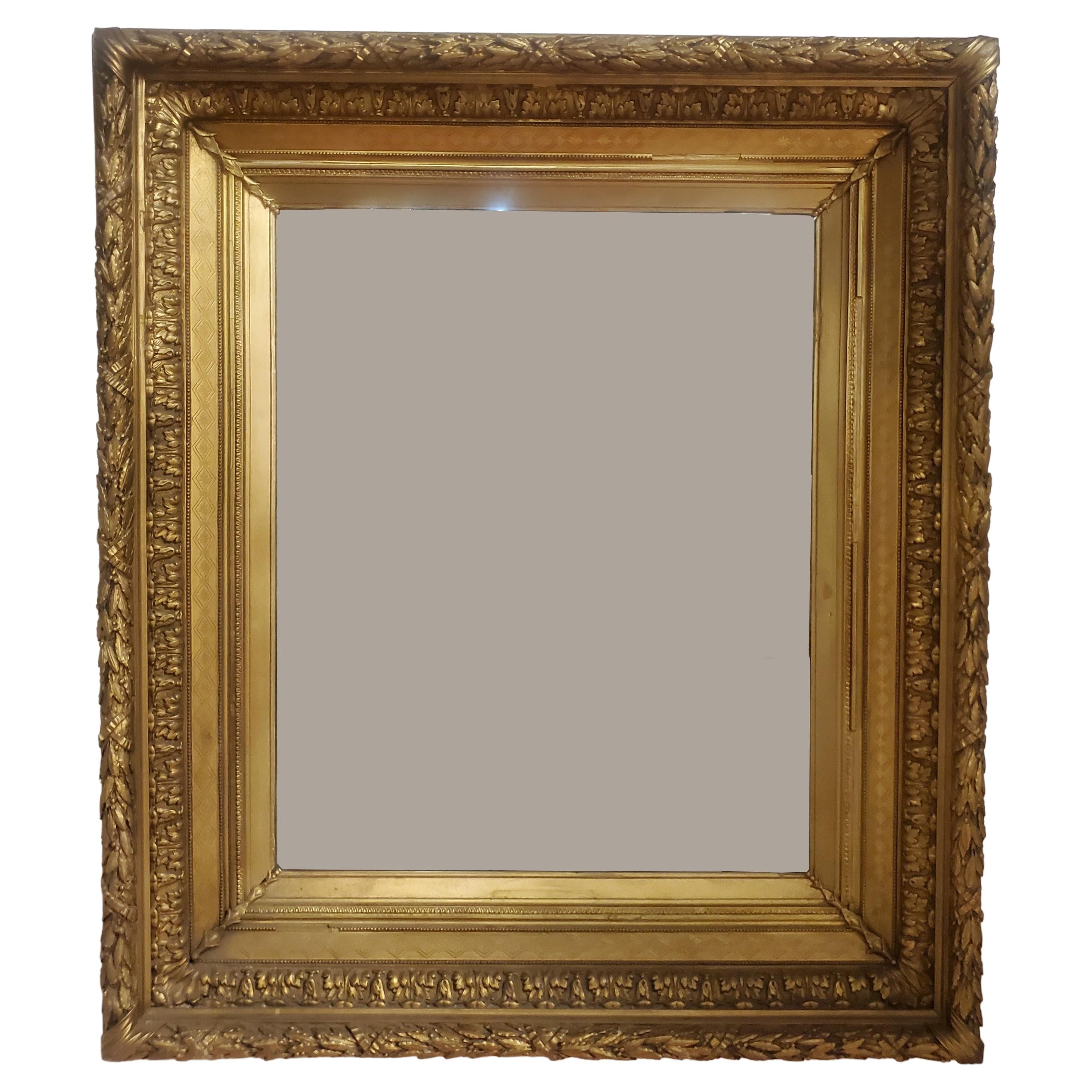 Large antique French gilt wood and gesso wall mirror circa 1890. An opulent and highly decorative Louis XVI style mirror featuring beautiful acanthus leaf design combined with delicate egg and dart bars. The impressively broad frame shows several
