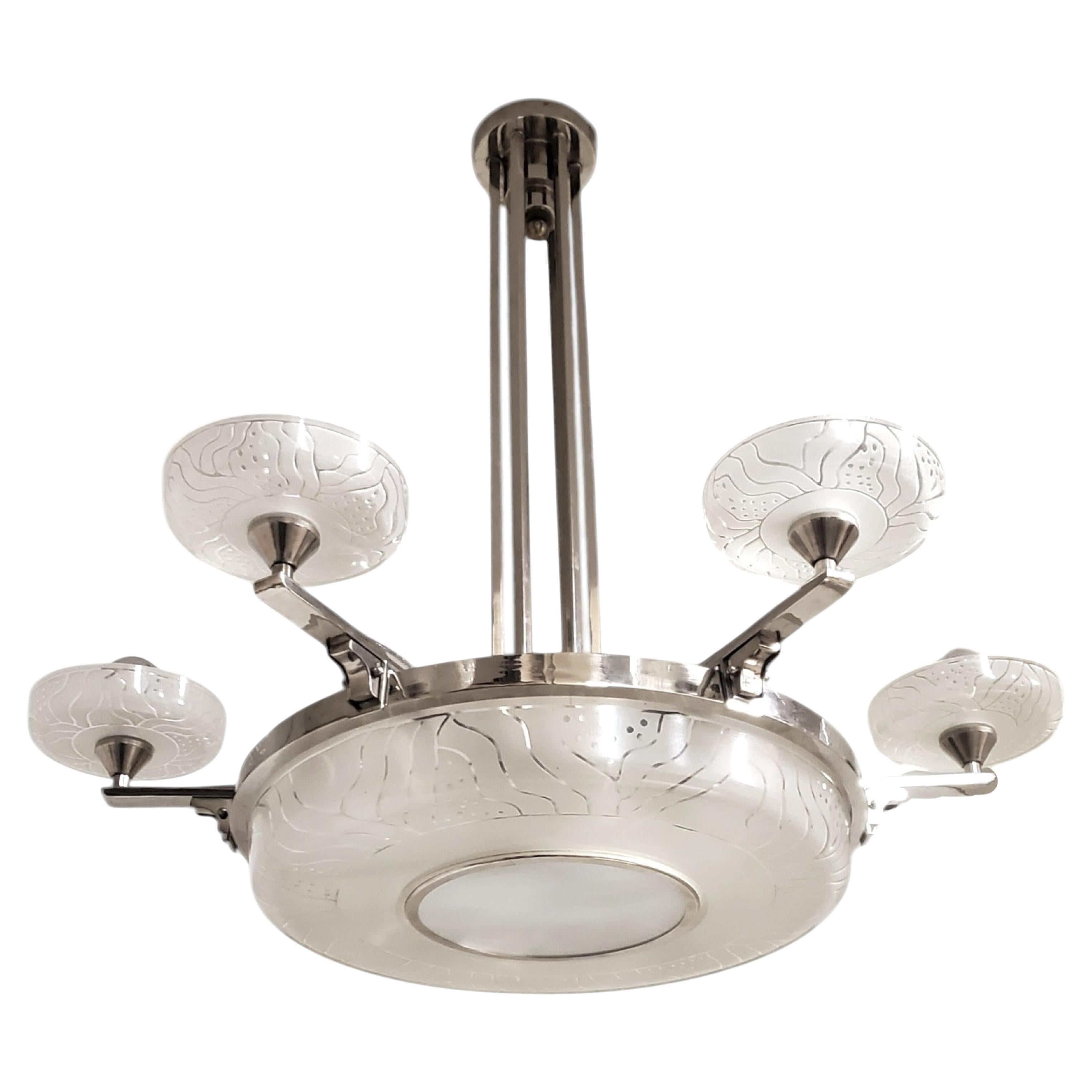 This original and elegant Modernist chandelier by Hettier Vincent and Verreries Hanots features a polished nickeled bronzed frame with six branch arms, each supporting six exquisitely textured acid etched art glass cup-shaped shades. 
The satellite