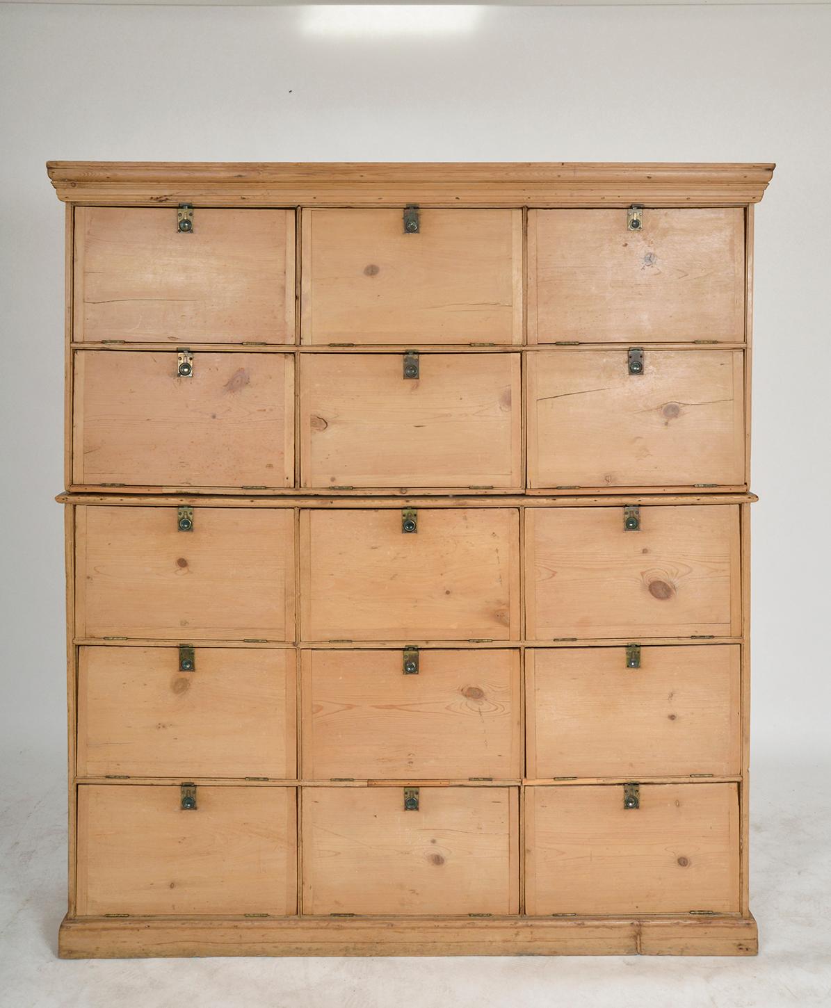 This large pine antique cupboard/locker with 15 cupboards dates from the late 19th / early 20th century, and was originally made for a local solicitors office. Inside a few of the drop-down doors, the original content text still remains, albeit
