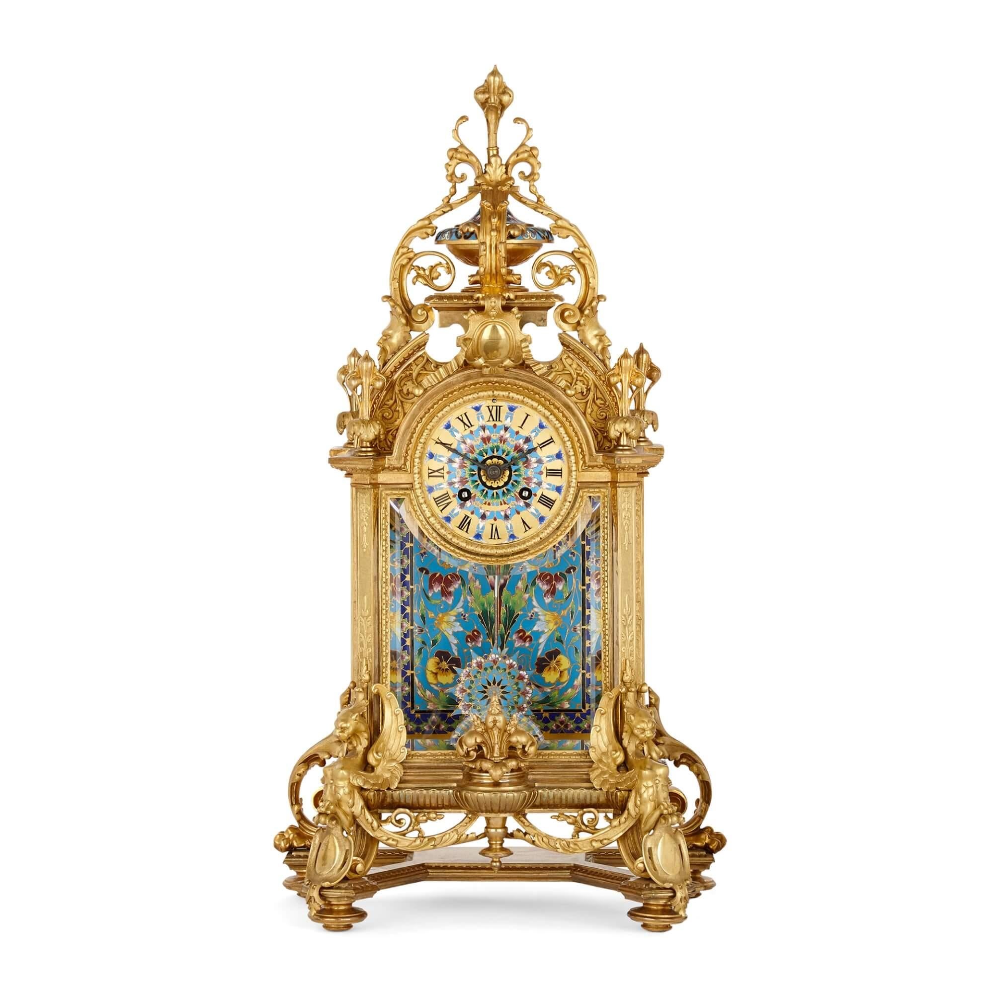 Large Ormolu and Cloisonné Enamel three piece clock set.
French, 19th Century
Clock: height 54cm, width 29cm, depth 17cm
Vases: height 35cm, width 15cm, depth 14cm

Comprising a clock and pair of flanking vases, all similarly decorated, this