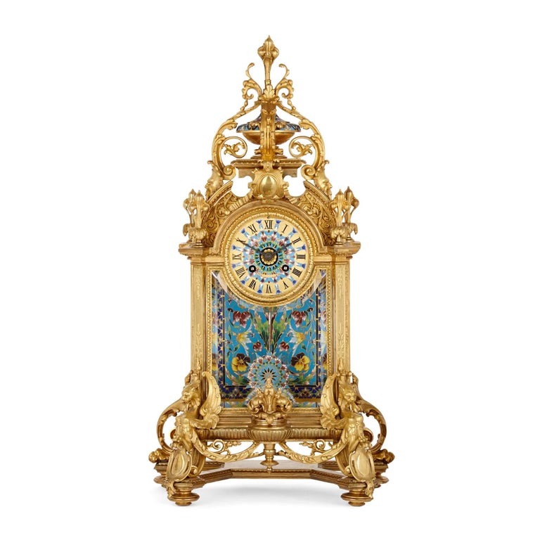 Large Ormolu and Cloisonné Enamel three piece clock set.
French, 19th Century
Clock: height 54cm, width 29cm, depth 17cm
Vases: height 35cm, width 15cm, depth 14cm

Comprising a clock and pair of flanking vases, all similarly decorated, this
