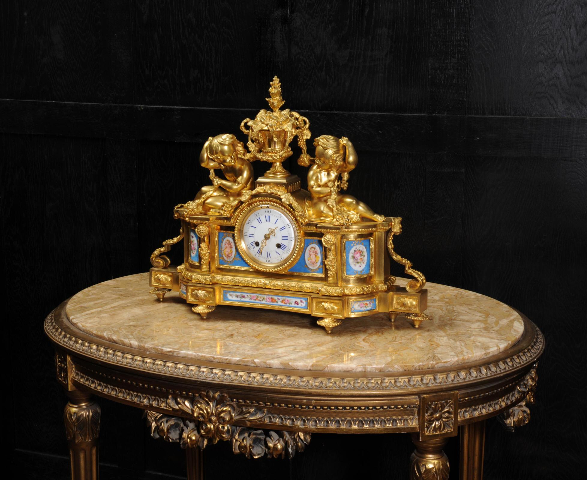 A very fine and early ormolu (finely gilded bronze) clock mounted with exquisite Sèvres style porcelain panels. Two seated cherubs sit each side of an urn, draped with vines, celebrating the grape harvest in a tribute to Bacchus, the Roman god of