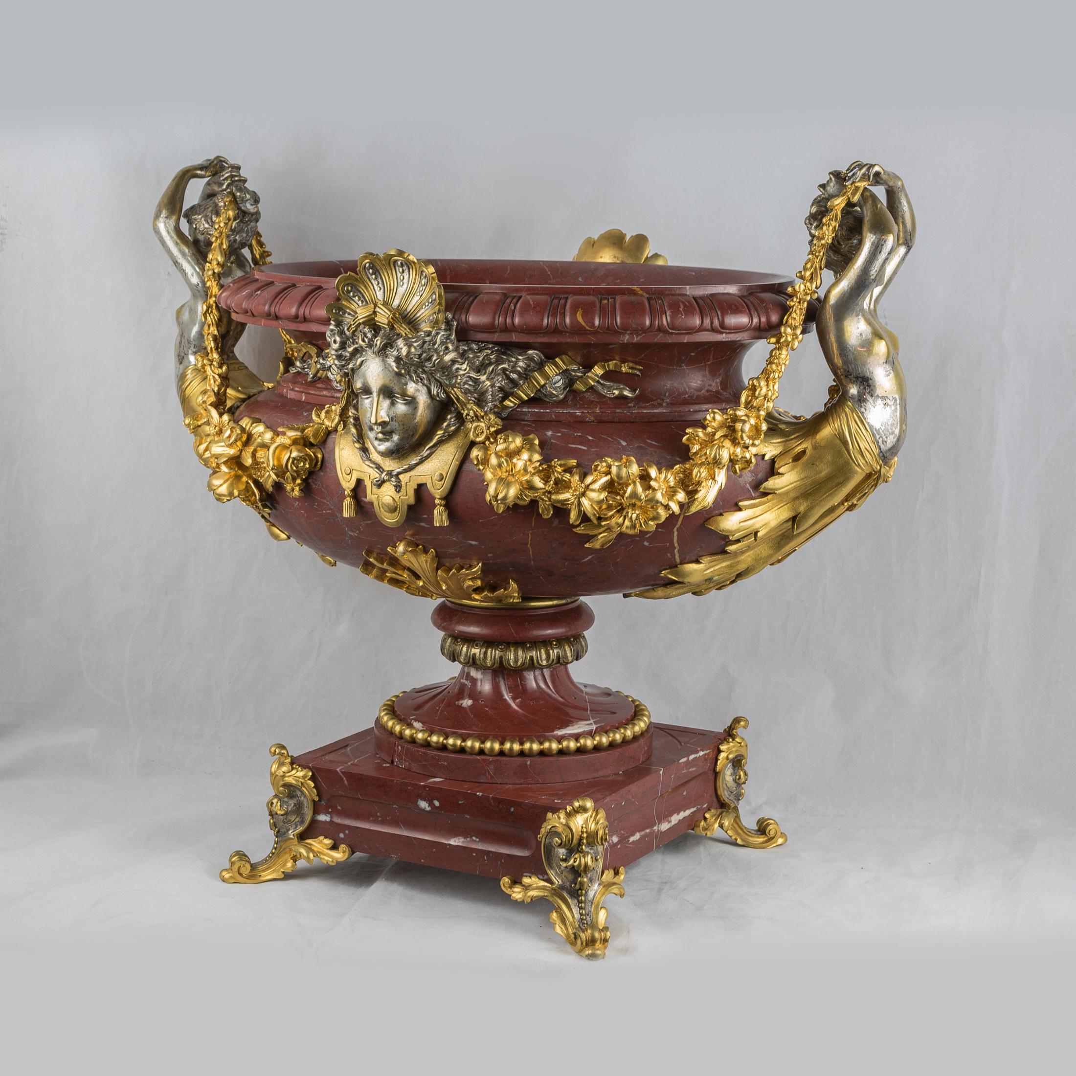 An Exquisite Ormolu-Mounted and Silvered-Bronze and Rouge Griotte Marble Centerpiece.
A mask in the front and reverse, flanked by female terms suspending fruiting swags. 

Origin: French
Date: 19th century
Dimension: 17 5/8 in. x 20 ½ in. x 12