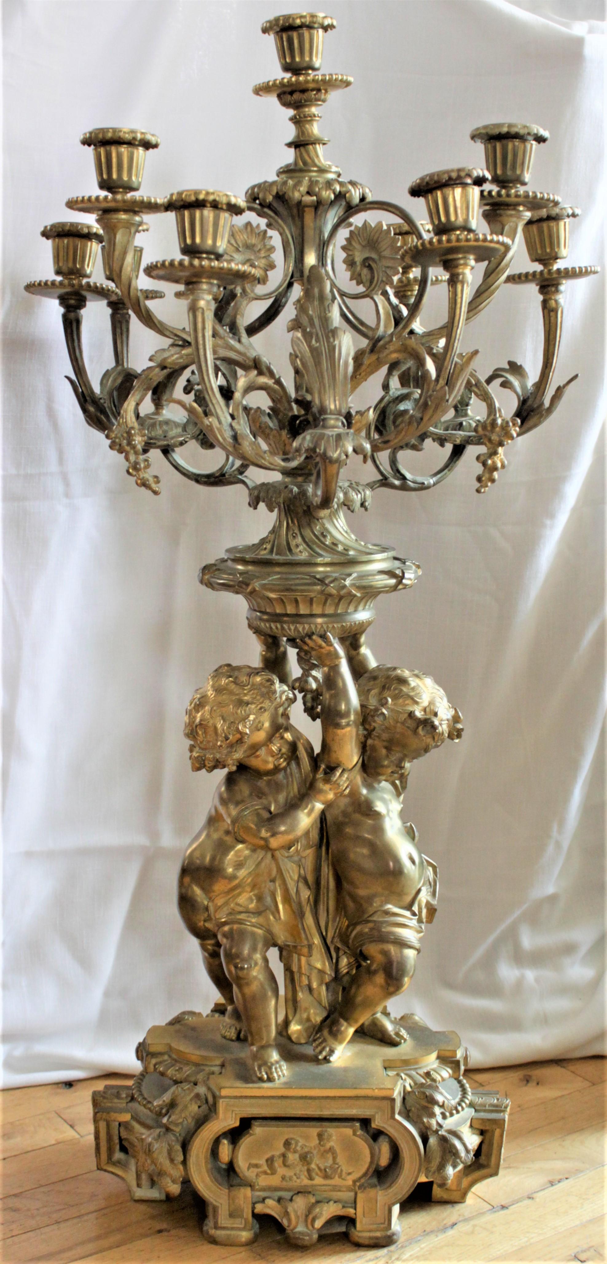 This very large and substantial antique gilt bronze candelabra shows no maker's marks, but is presumed to have been made in France in circa 1880 in the Louis Phillipe style. The candelabra is ornately cast and features two children on the base