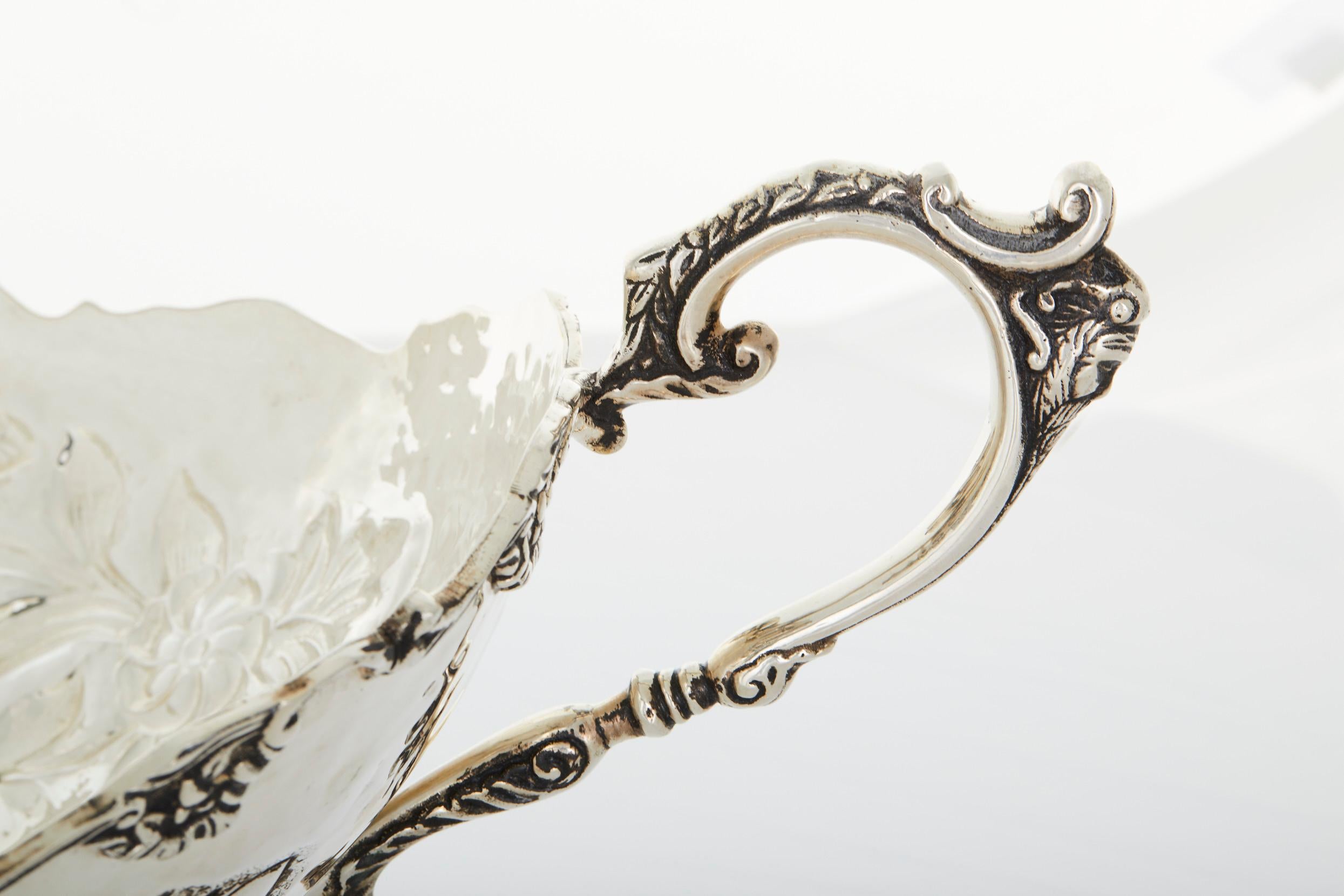 Early 20th century large Italian silver plate decorative piece / barware wine cooler . The piece features a round footed base with ornately exterior floral design detail and two side handles . The piece is in great condition . Minor wear consistent