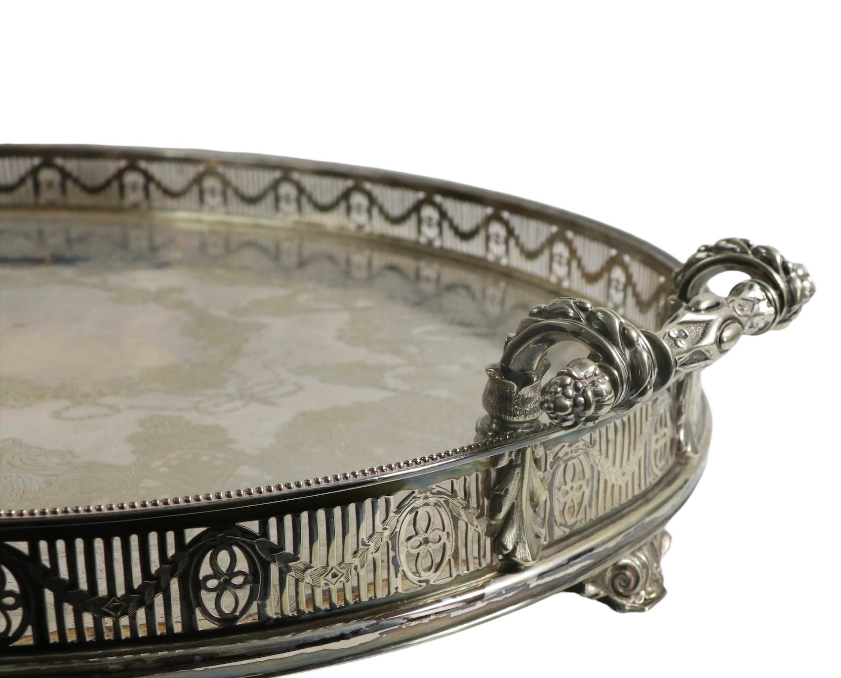Excepcional bandeja de plata plateada, de forma ovalada con una galería de adornos perforados, asas ornamentadas y pies decorativos. La superficie central está fina e intrincadamente decorada, la factura es exquisita y el estado es muy bueno. El