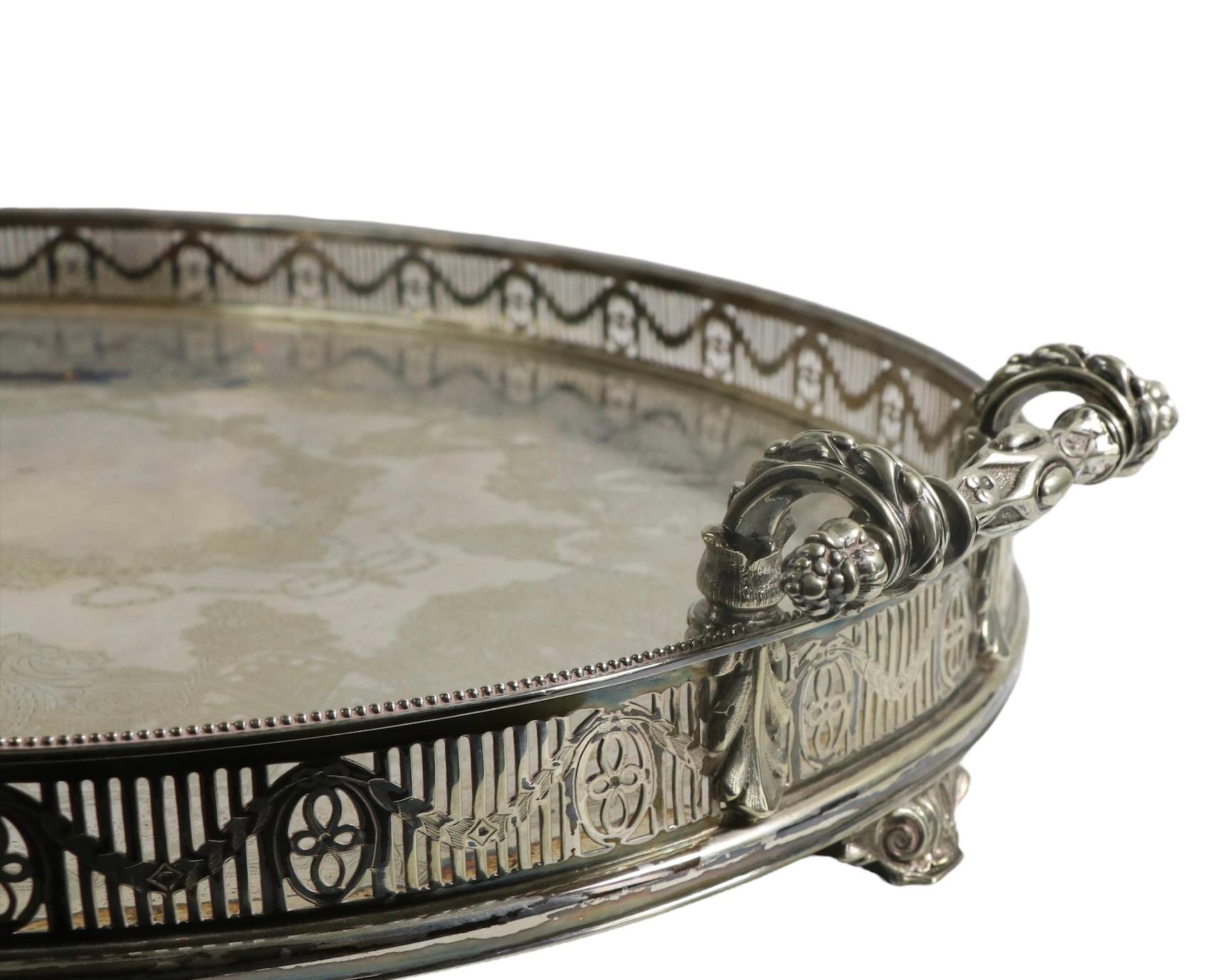 Exceptional silver plate tray, of oval form having a pierced trim gallery, ornate handles and decorative feet. The center surface is finely and intricately decorated, the workmanship is exquisite and the condition is very good. The only flaw being a