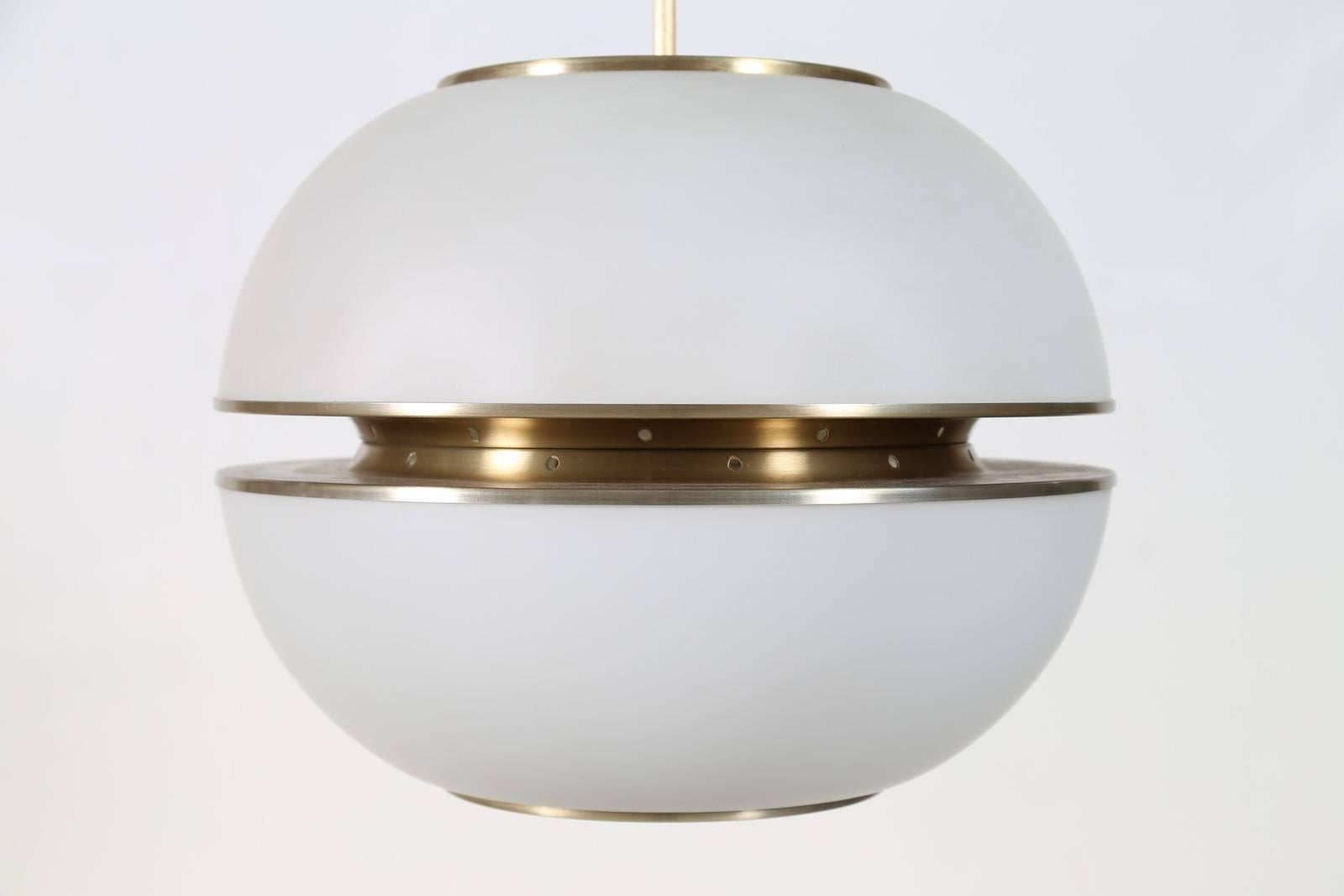 Oscar Torlasco (1934-2004)

A large and imposing modernist Lumi chandelier attributed to Oscar Torlasco, in spherical white opaline glass bisected by sleek brass-colored satin finish metal mounts. 

Italy, 1960's.

Lumi Milano maker’s mark at top of