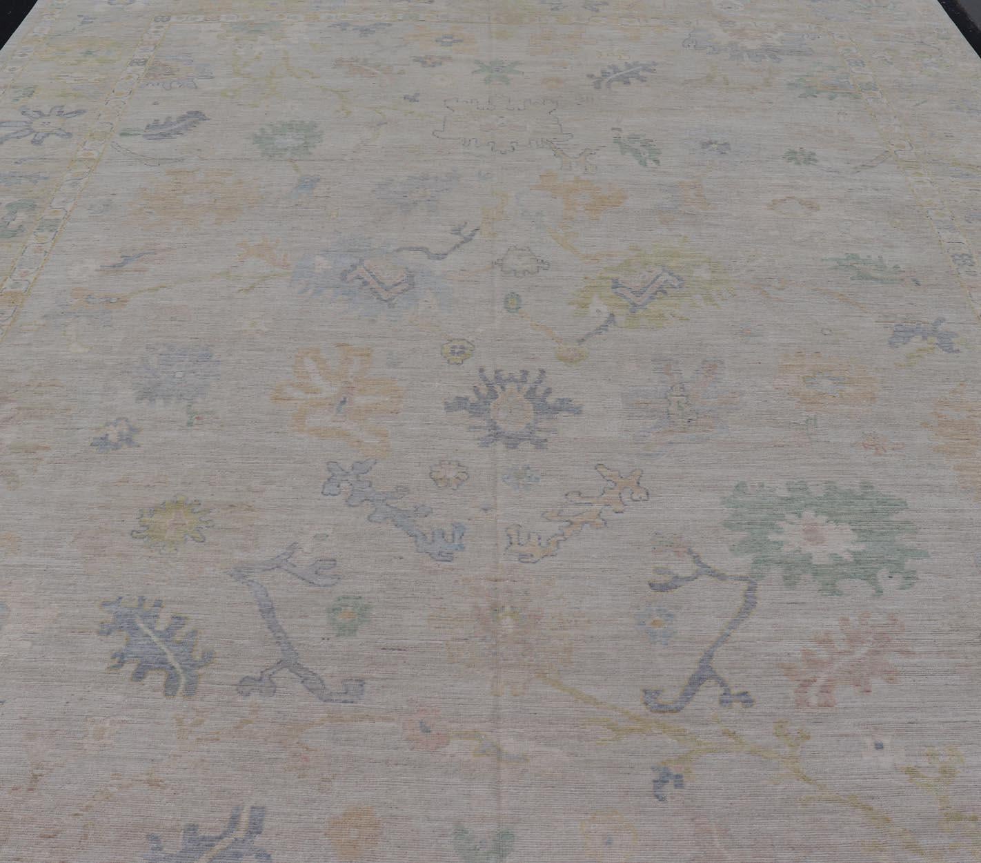  Großer Oushak-Teppich mit floralen Motiven und gedämpften, bunten Tönen auf neutralem Hintergrund.

   Großer Oushak-Teppich mit floralen Motiven und gedämpften Farbtönen von Keivan Woven Arts.  Keivan Woven Arts; Teppich AWR-17857 Herkunftsland: