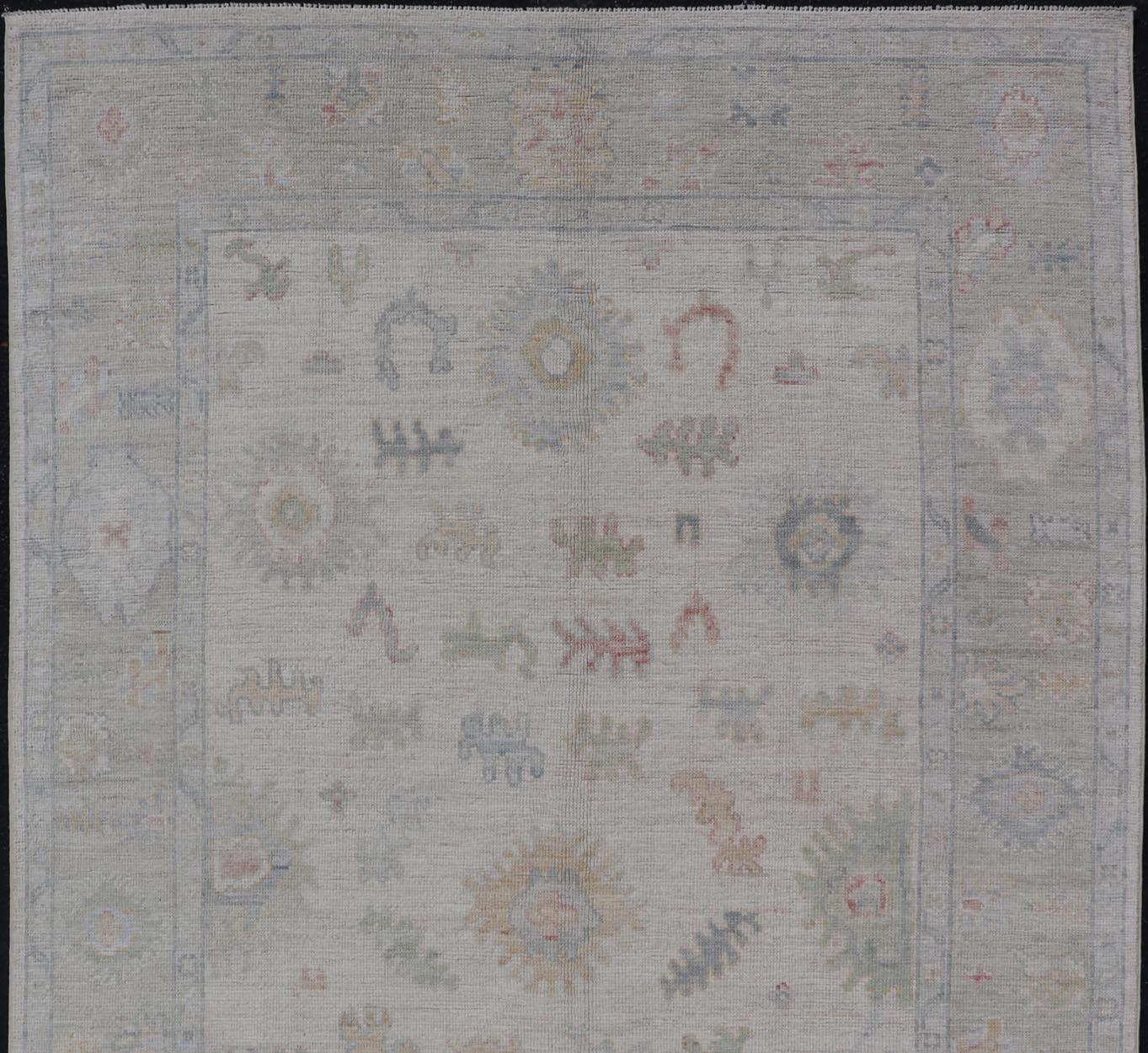Hand-Knotted Large Oushak Rug with Floral Motifs & Muted Colorful Tones on Neutral Background For Sale