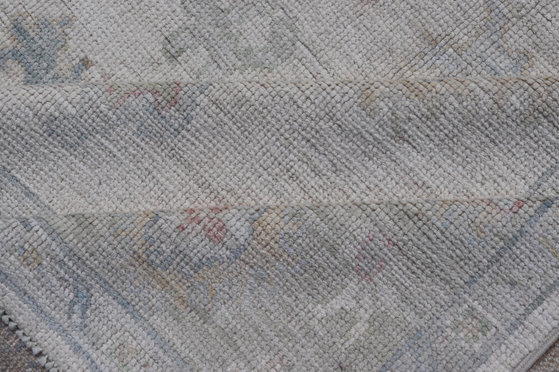 Wool Large Oushak Rug with Floral Motifs & Muted Colorful Tones on Neutral Background For Sale
