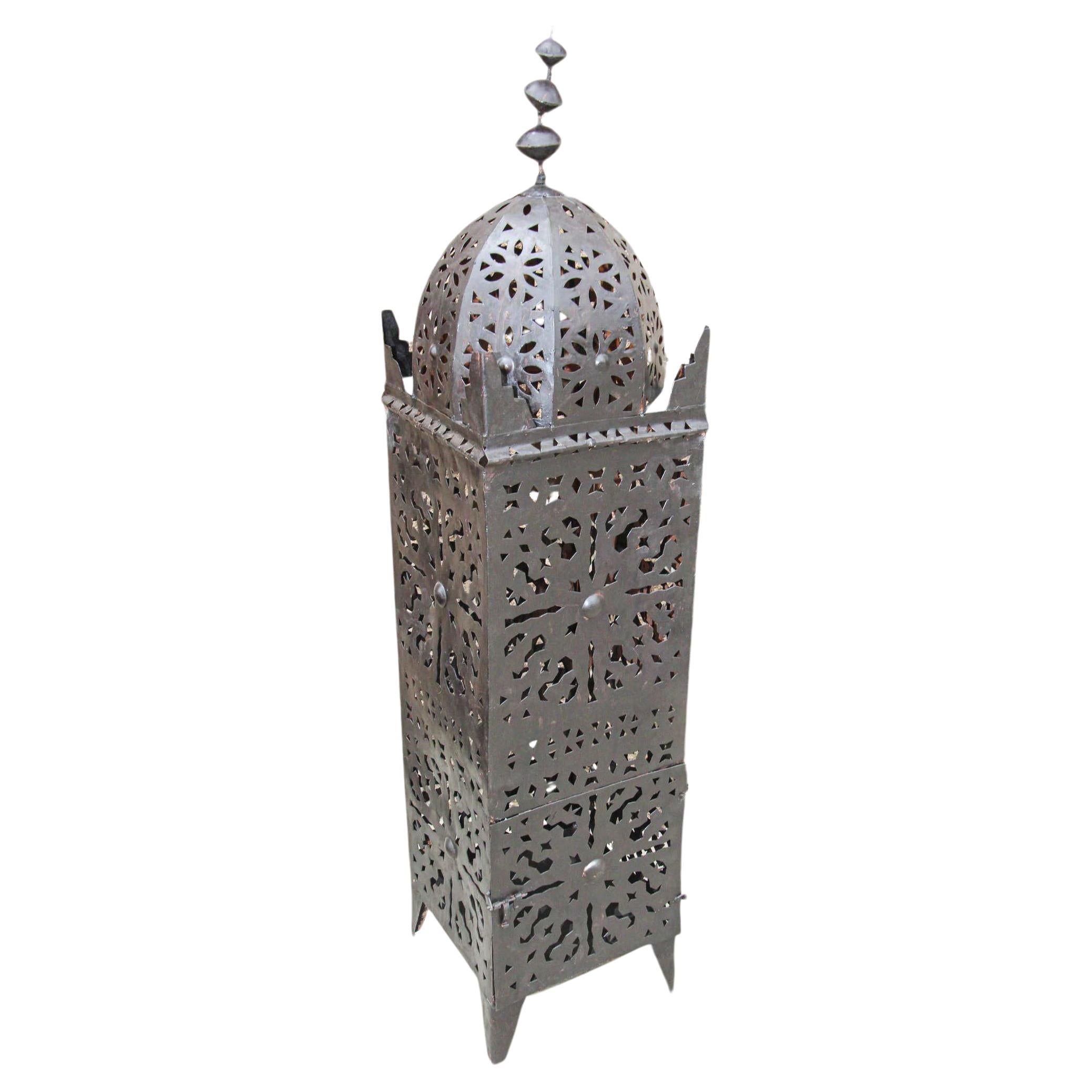 Large outdoor vintage Moroccan metal candle lantern.
Hurricane Kasbah shaped candle lamp handcrafted in Morocco by artisans, metal hand-cut and hammered, opening in front for use with pillar candles.
The lantern has a small door to access the