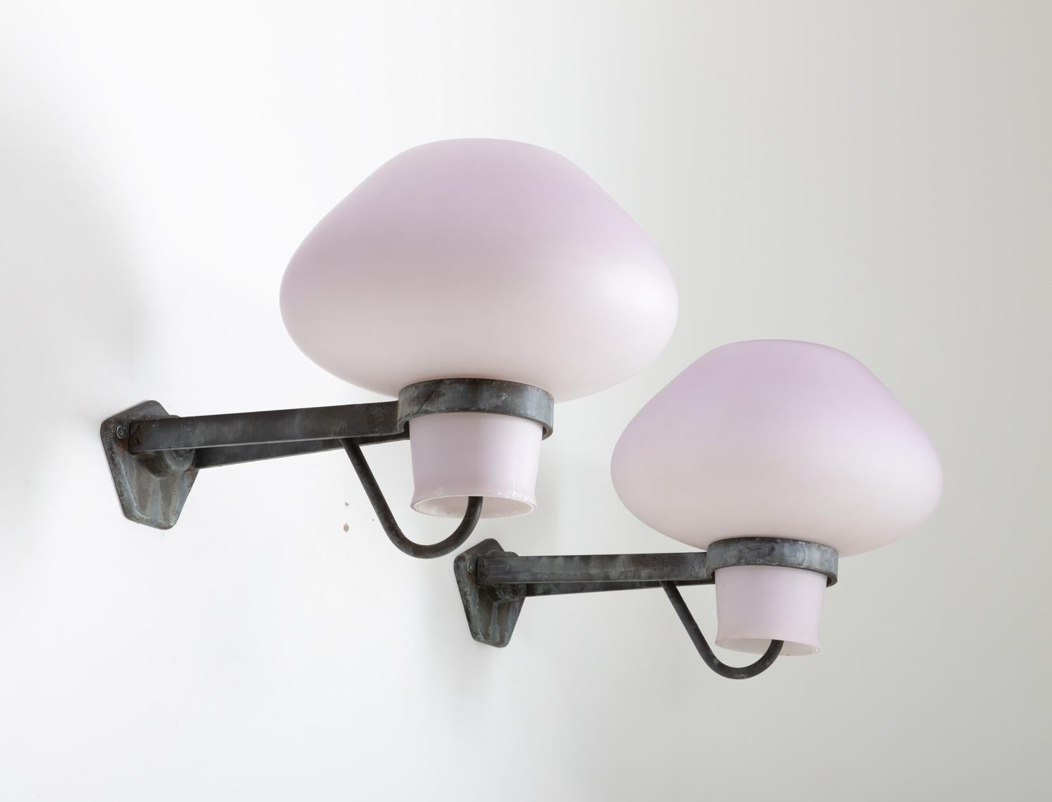 Large outdoor wall lamps by Gunnar Asplund for ASEA, 1940s. 
These lamps feature a very large frosted opaline glass shade, resting on a frame of metal with beautiful patina.

Condition: Good original condition. Some wear and spots on the shades