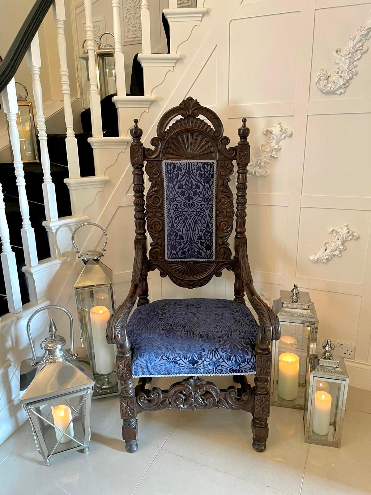 Large outstanding antique Victorian quality carved oak throne armchair having a quality shaped carved top rail with original turned finials supported by two turned carved columns. A delightful carved back with a newly reupholstered seat and back