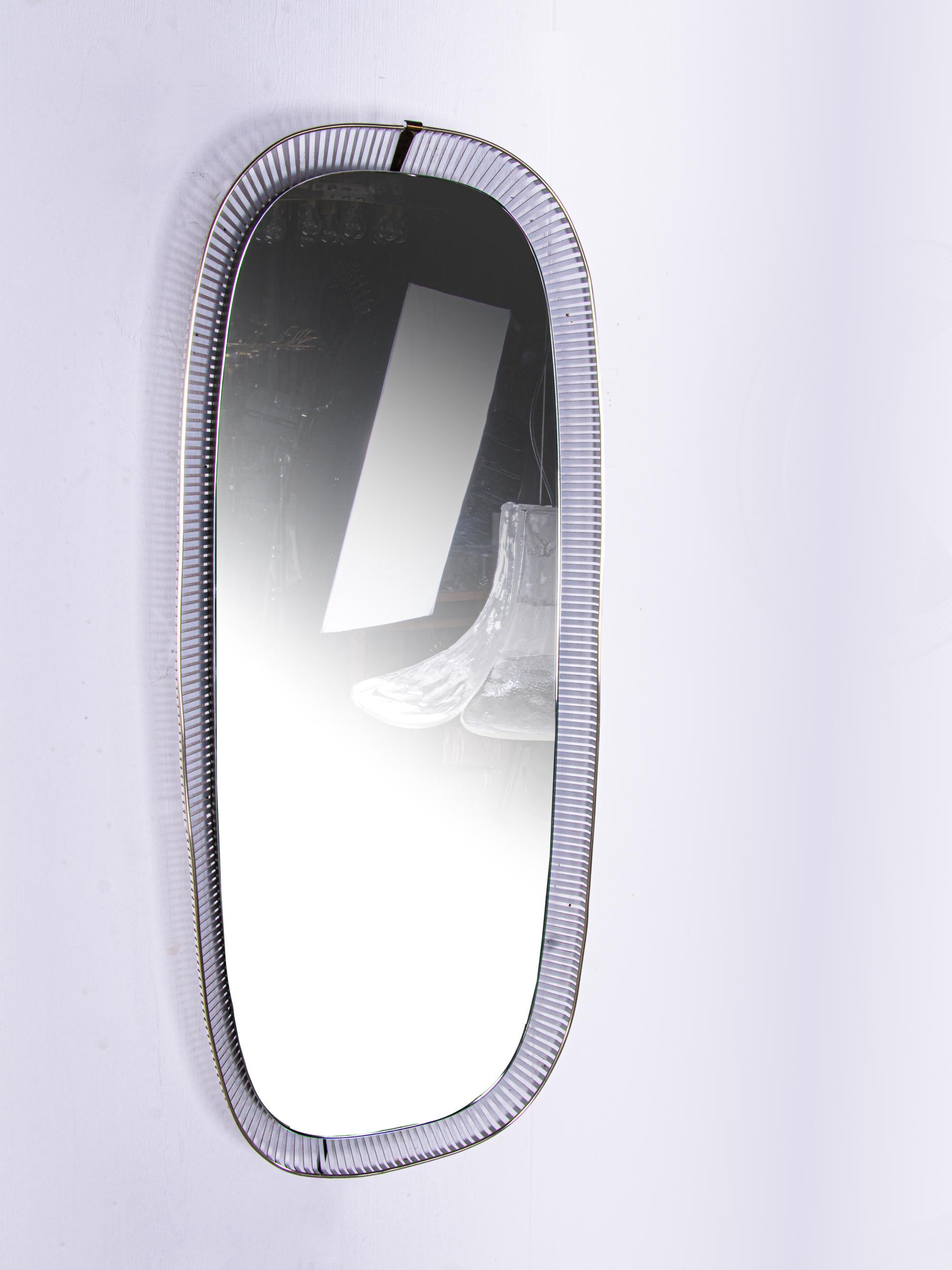 Elegant grand miroir mural ovale avec fond éclairé. Fabriqué en Allemagne, années 1950. 
 
Le cadre est en tôle perforée avec des ferrures en laiton. 

Dimensions : hauteur : environ 111 cm, largeur : environ 47,5 cm, profondeur : environ 8 cm.