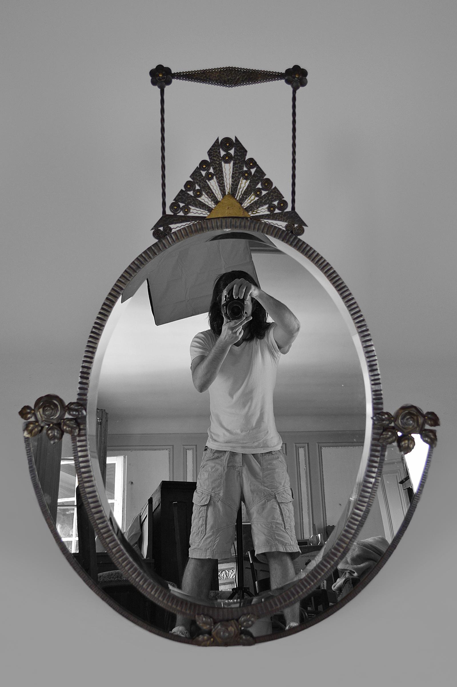 Wunderschöner Wandspiegel, bestehend aus einem großen abgeschrägten ovalen Spiegel, 2 kleinen halbmondförmigen Spiegeln und einem prächtigen schmiedeeisernen Rahmen zum Thema Nature (Muster aus Blumen, Blättern und Sonne). Die Sonne und ihre