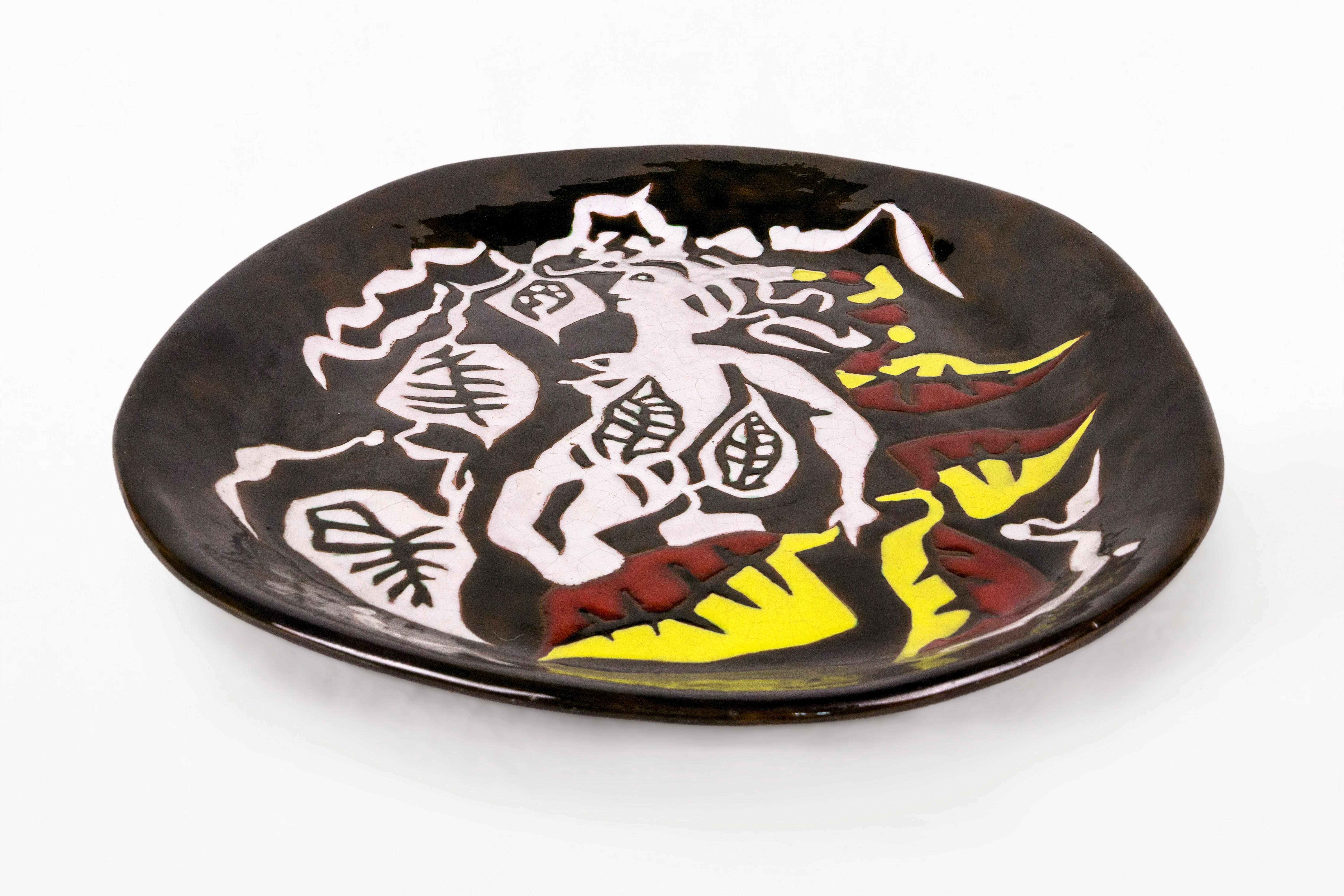 DESCRIPTION : Grande assiette ovale en céramique Baccanal par Jean Lurçat, Circa 1950, France.
Grande assiette ovale en céramique, avec une décoration centrale d'une scène baccanale stylisée avec un personnage et des feuilles. Fond noir glacé avec