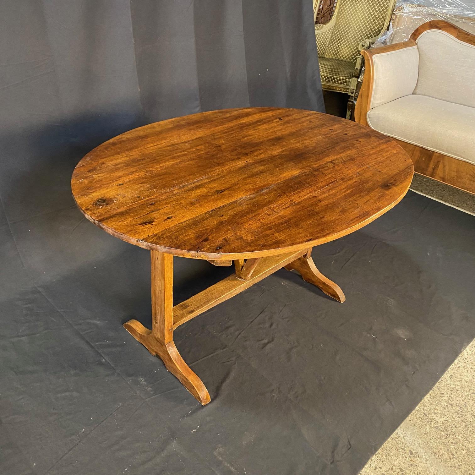 Belle et grande table de vendange française, vers la fin des années 1800. Plateau ovale généreux sur une base à tréteaux avec un mécanisme de harpe triangulaire. Jolis pieds arrondis sculptés à la main. Tilt-top entièrement fonctionnel et pouvant