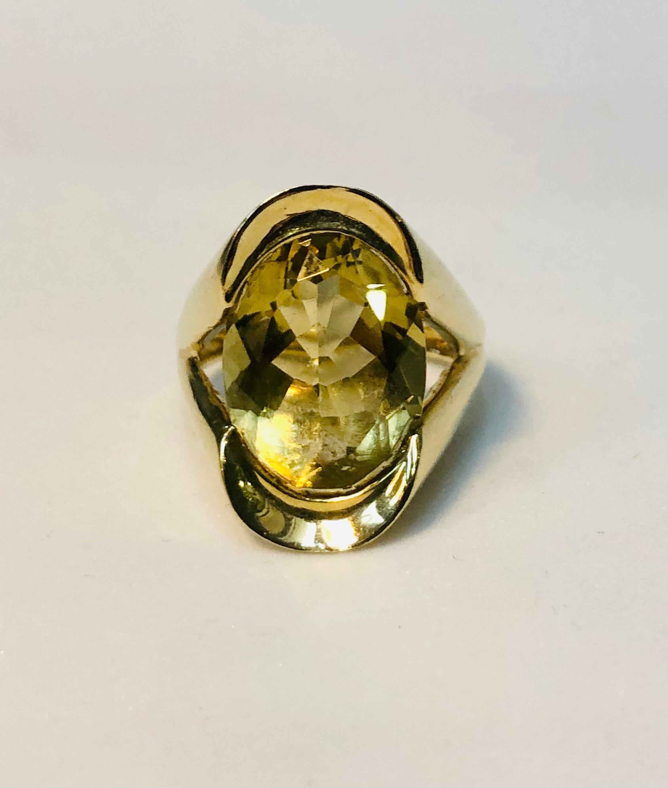 Large oval cut citrine cocktail ring. The stone is set in an architectural gold design resembling a V shape. A beautifully faceted lemon coloured citrine stone catches the light and the eye. Ring size 6 1/4. 

Length 2.2 cms 
Width 1.2 cms
Weight