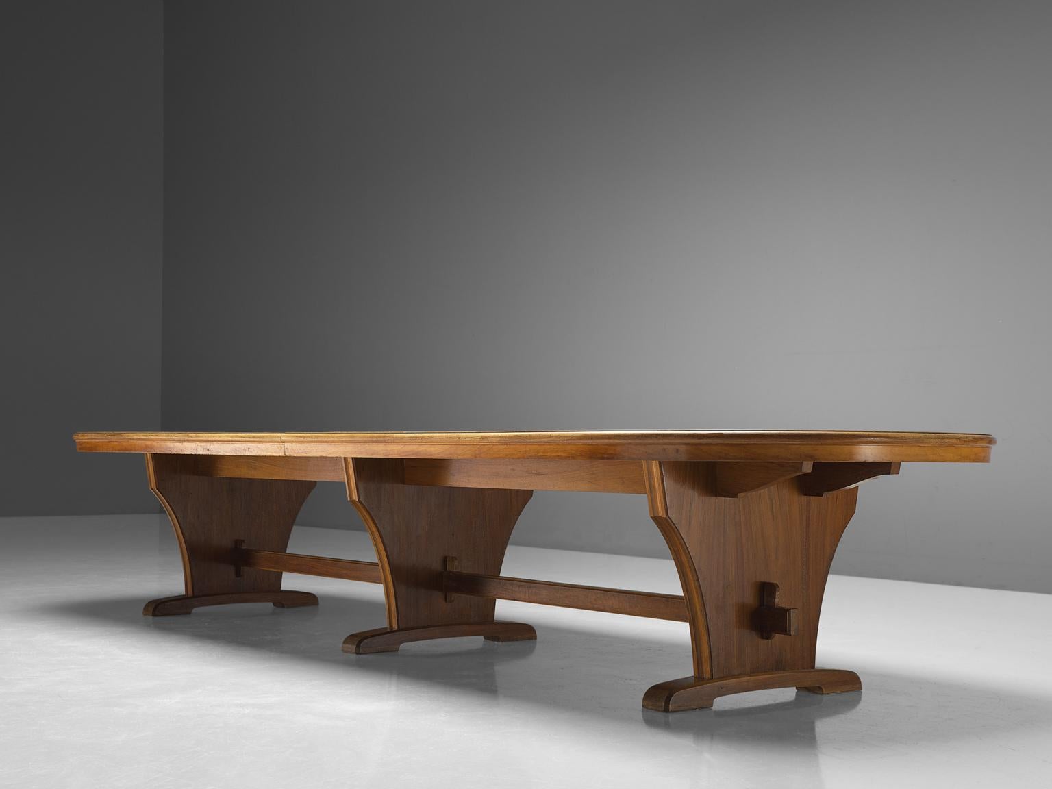 Conference table, veneered walnut, Germany, 1950s

Very large oval dining-/conference table with three, very elegant, legs. The wonderful mirrored grain of the bookmatched Italian walnut is beautifully framed with an inlays border in the same