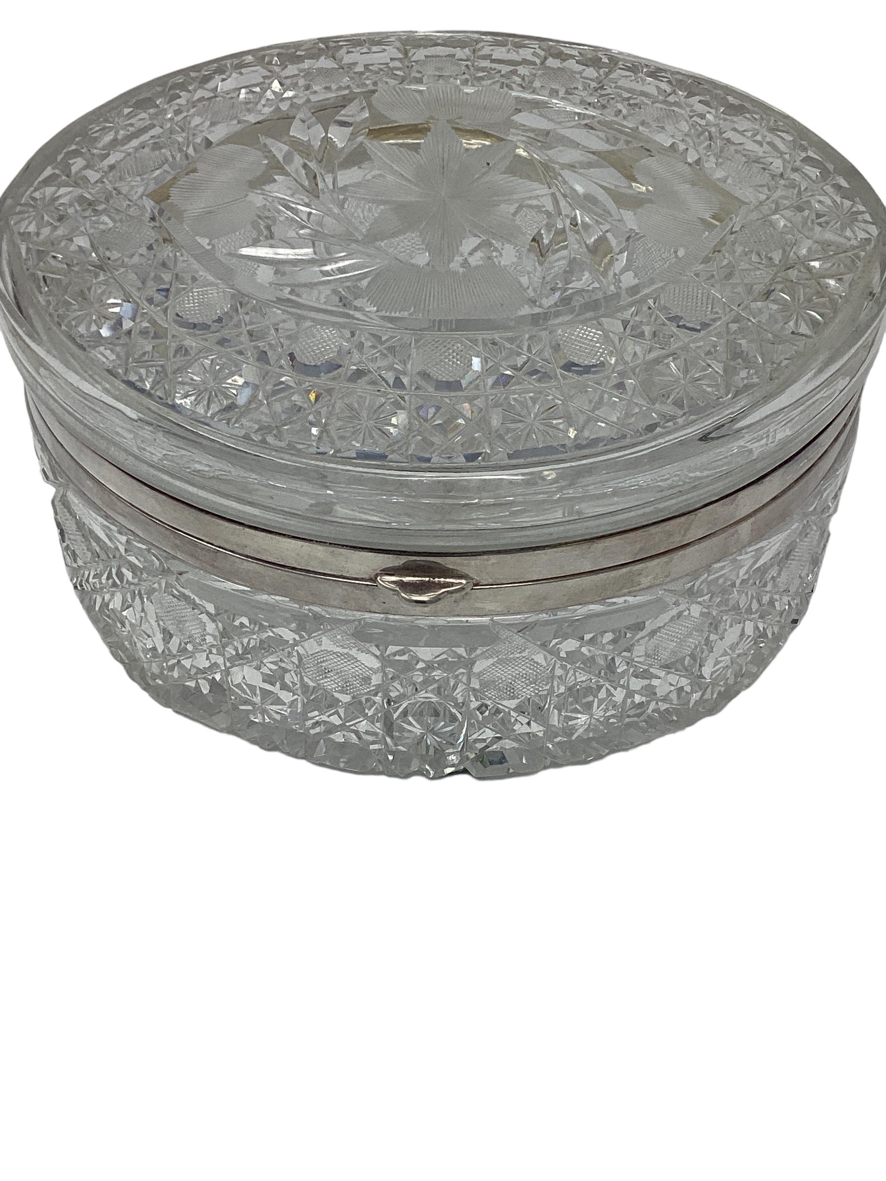 Large Oval Cut Crystal Box with Silver Mount.  Cut crystal boxes are typically made from high-quality lead crystal glass. This type of glass is known for its clarity, brilliance, and ability to refract light beautifully. The deep wheel cut pattern