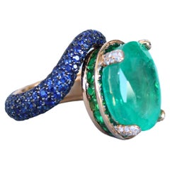 Großer Ring aus 18 Karat Gold mit Smaragd im Ovalschliff und Vollpavé- Tsavorit, Diamanten, Saphiren und Saphiren