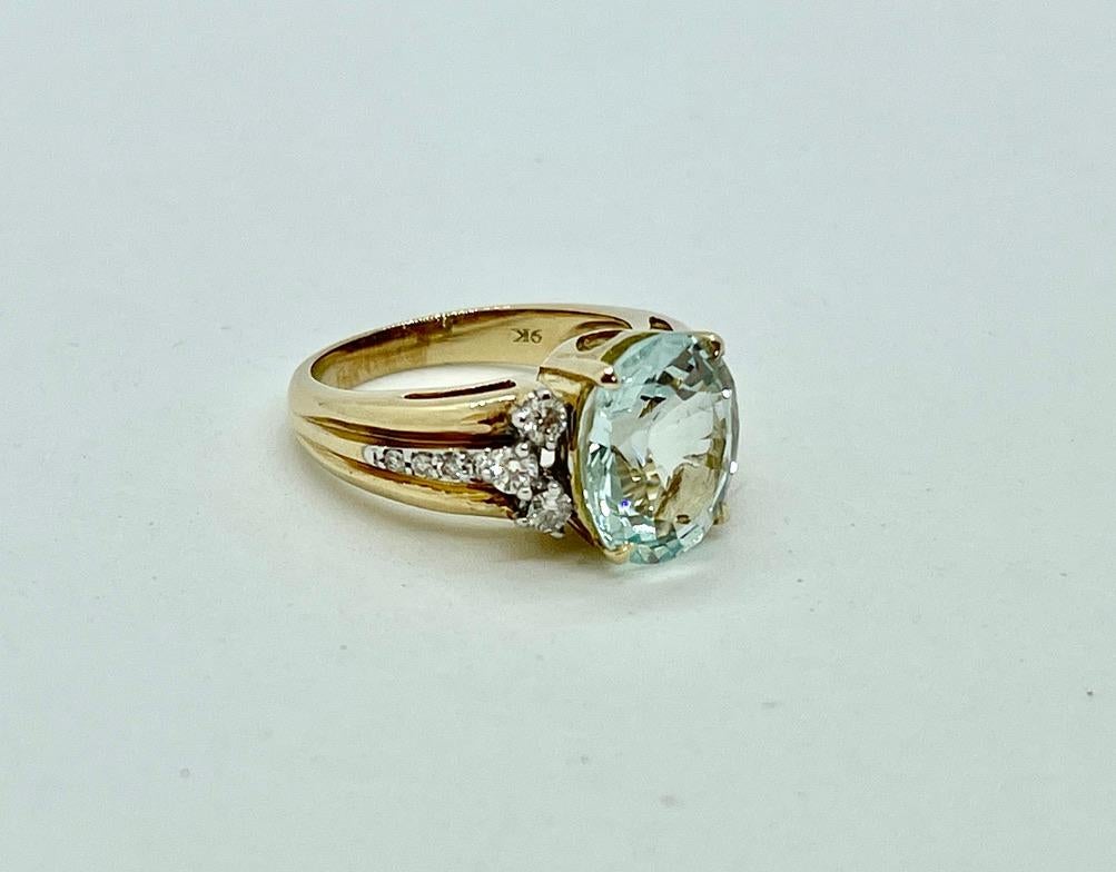 This well made ring is set with a large, round cut, 4.16ct natural Aquamarine and Diamonds in 9ct yellow gold. The Aquamarine is moderately light in colour, very clean and it is well cut.  There are 12 x Round Brilliant Cut Diamonds on the shoulders