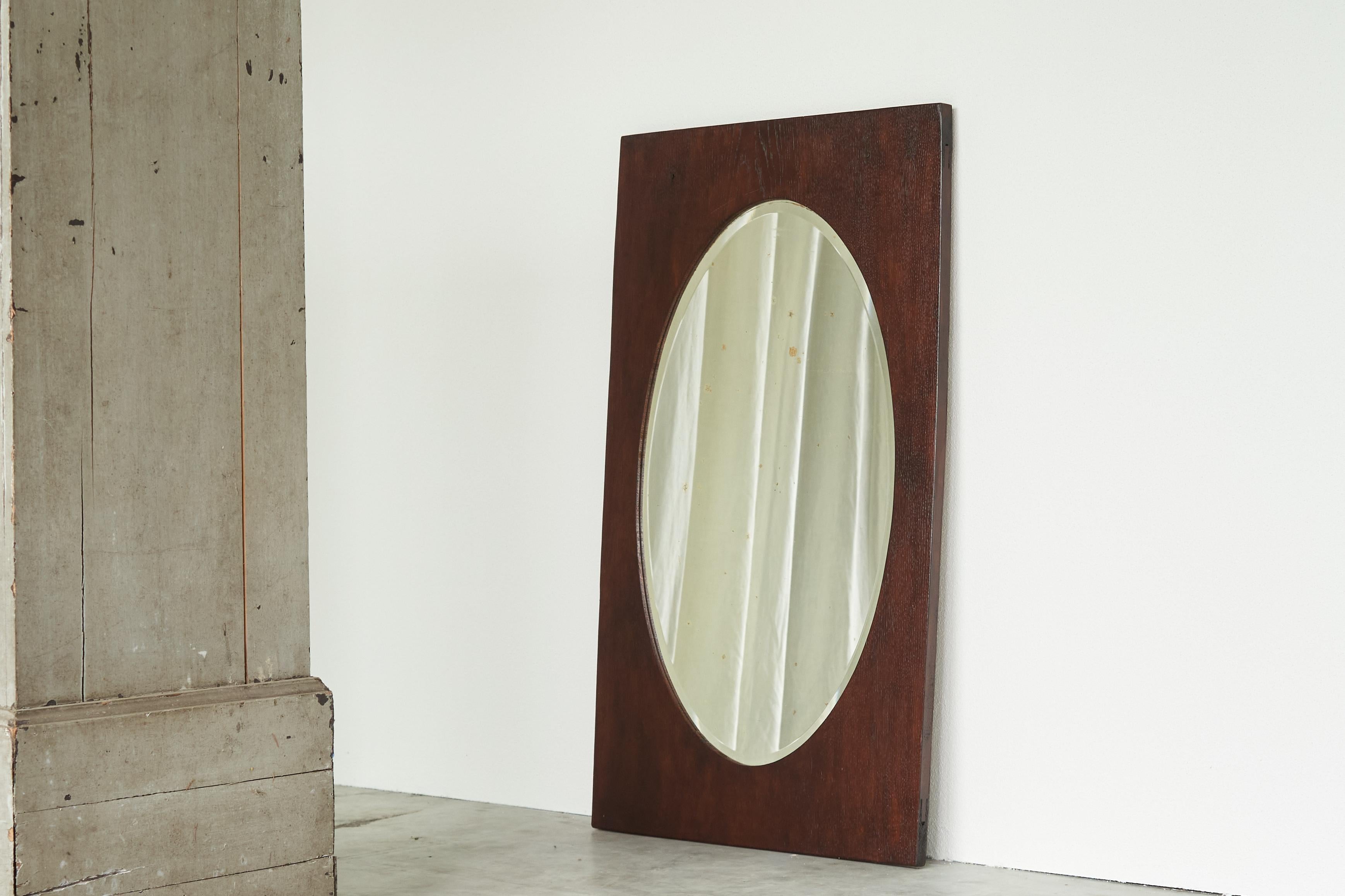 Oval Facetted Mirror in a Rectangular Oak Frame 1920s

This early 20th century mirror features a striking design with an oval-shaped mirror plate set within a rectangular wooden frame. The proportions are very well chosen, in all its modesty it has
