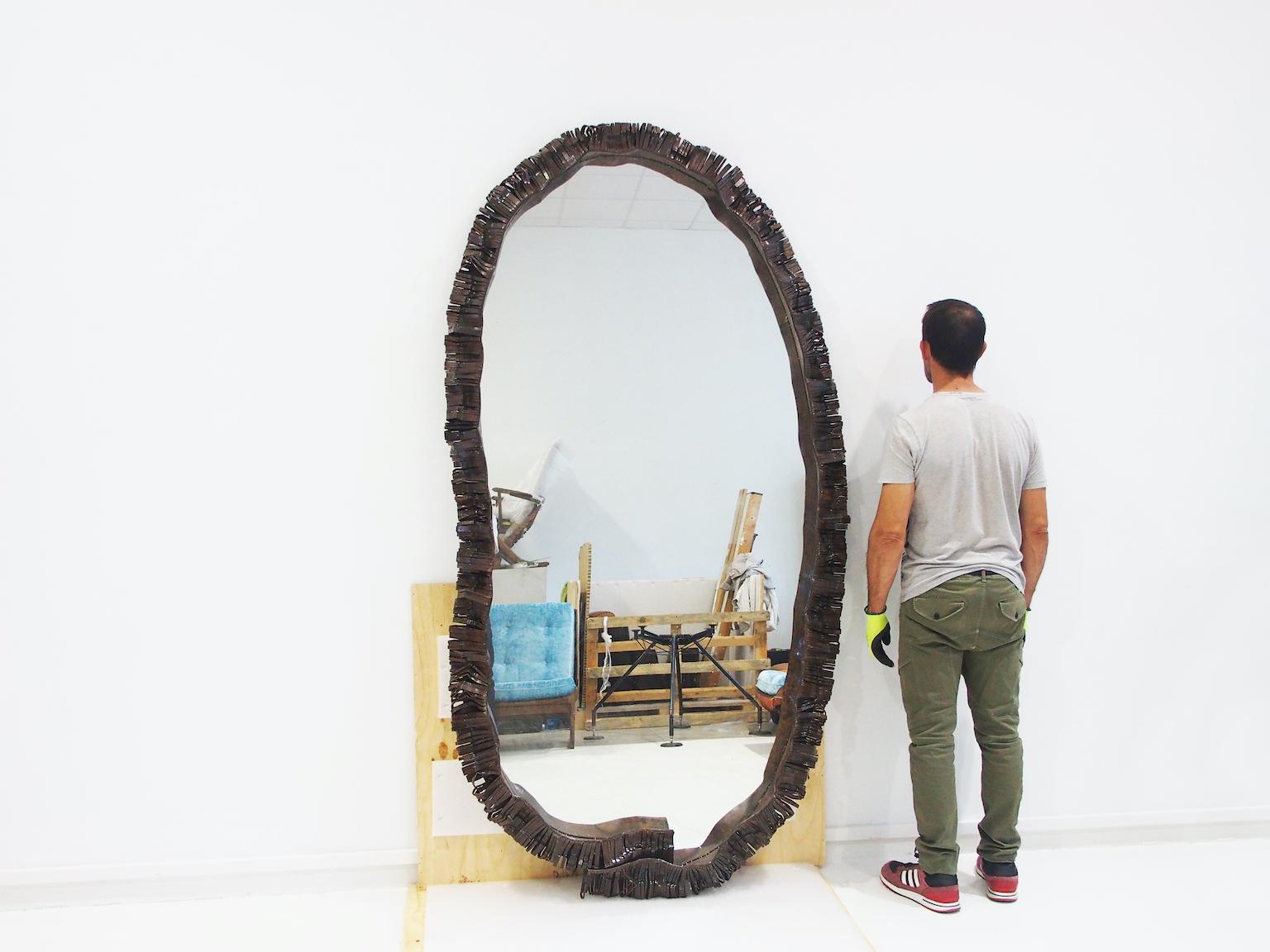 Grand miroir au sol de forme ovale organique avec bord en fer forgé. Fabriqué en Italie dans les années 1970. Légère usure due à l'âge.