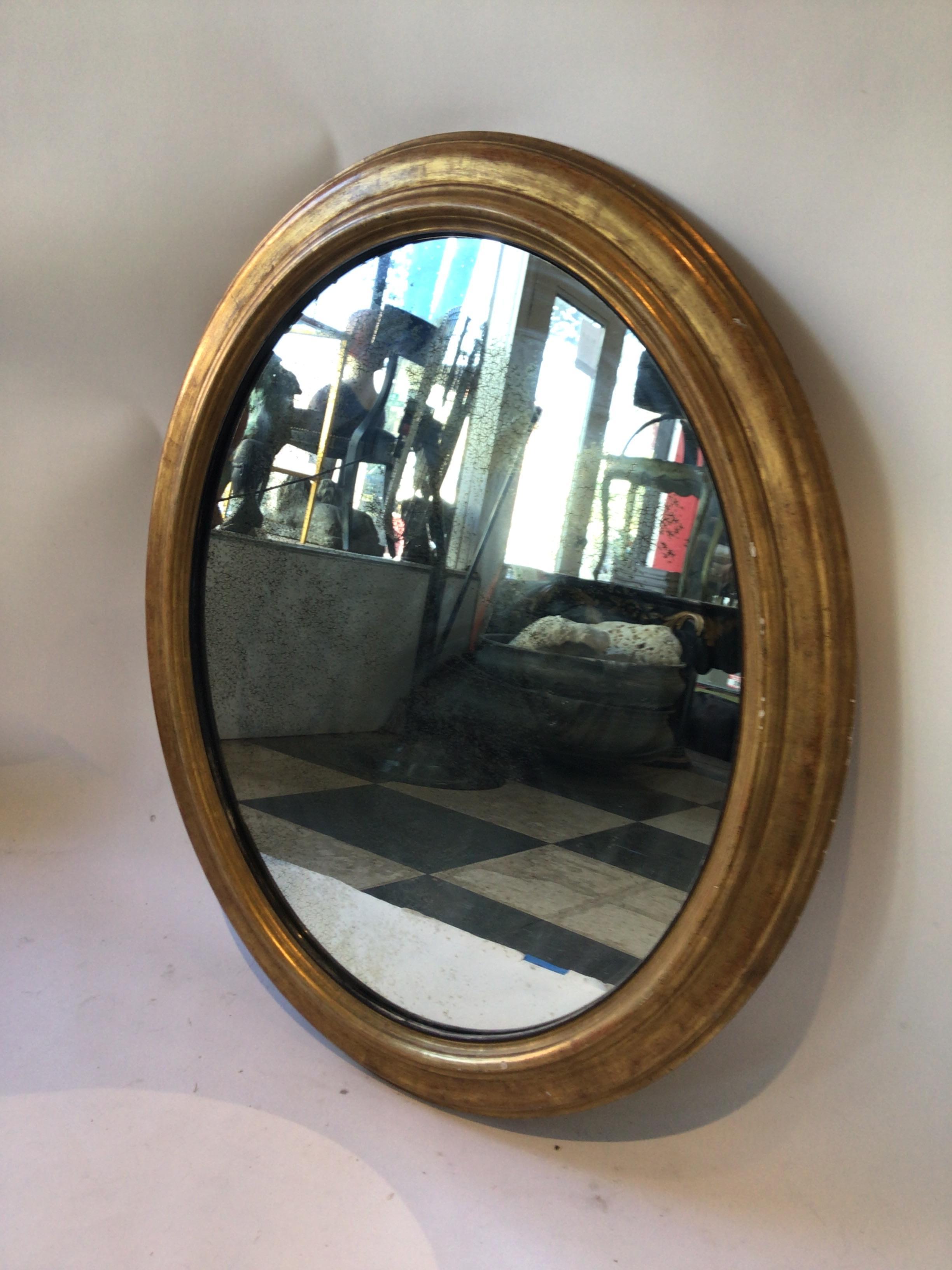 Mid-20th Century Large Oval Gilt Wood Mirror with Aged Glass For Sale
