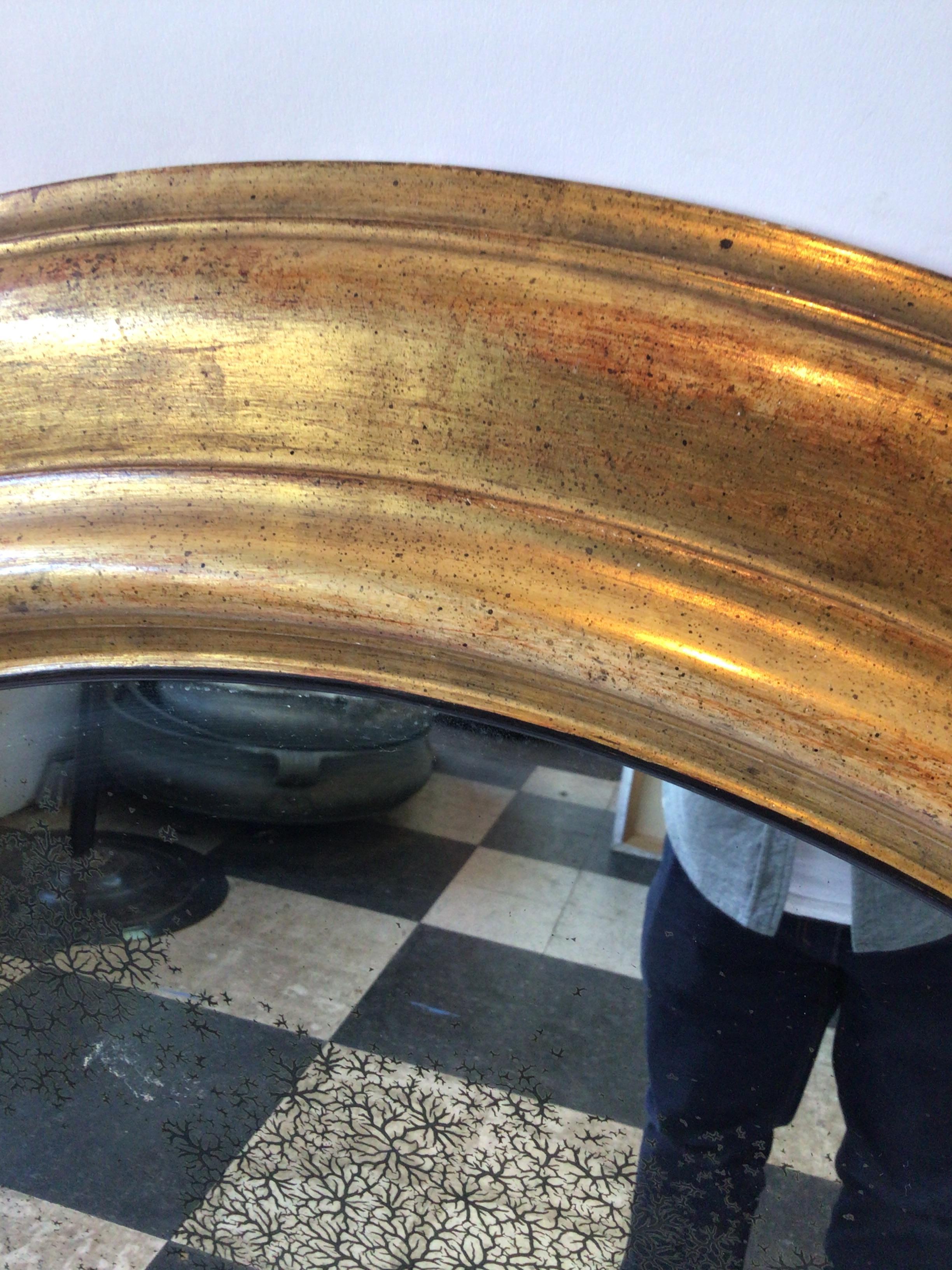 Milieu du XXe siècle Grand miroir ovale en bois doré avec verre vieilli en vente