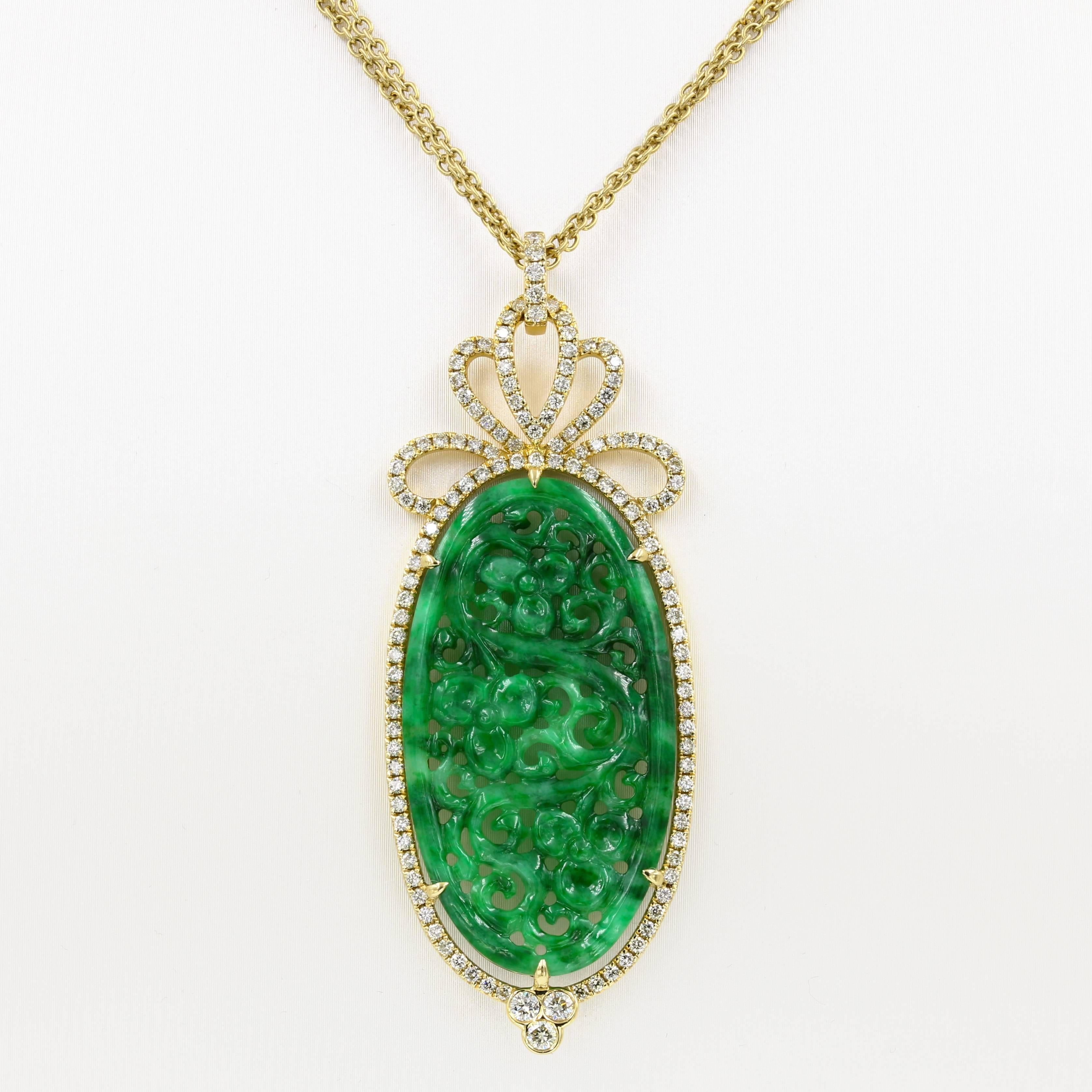 This elegant necklace in 18kt. yellow gold contains a carved oval green jade (approx. 21x40mm) surrounded by 131 round diamonds= 1.26cts. t.w. The necklace is 20