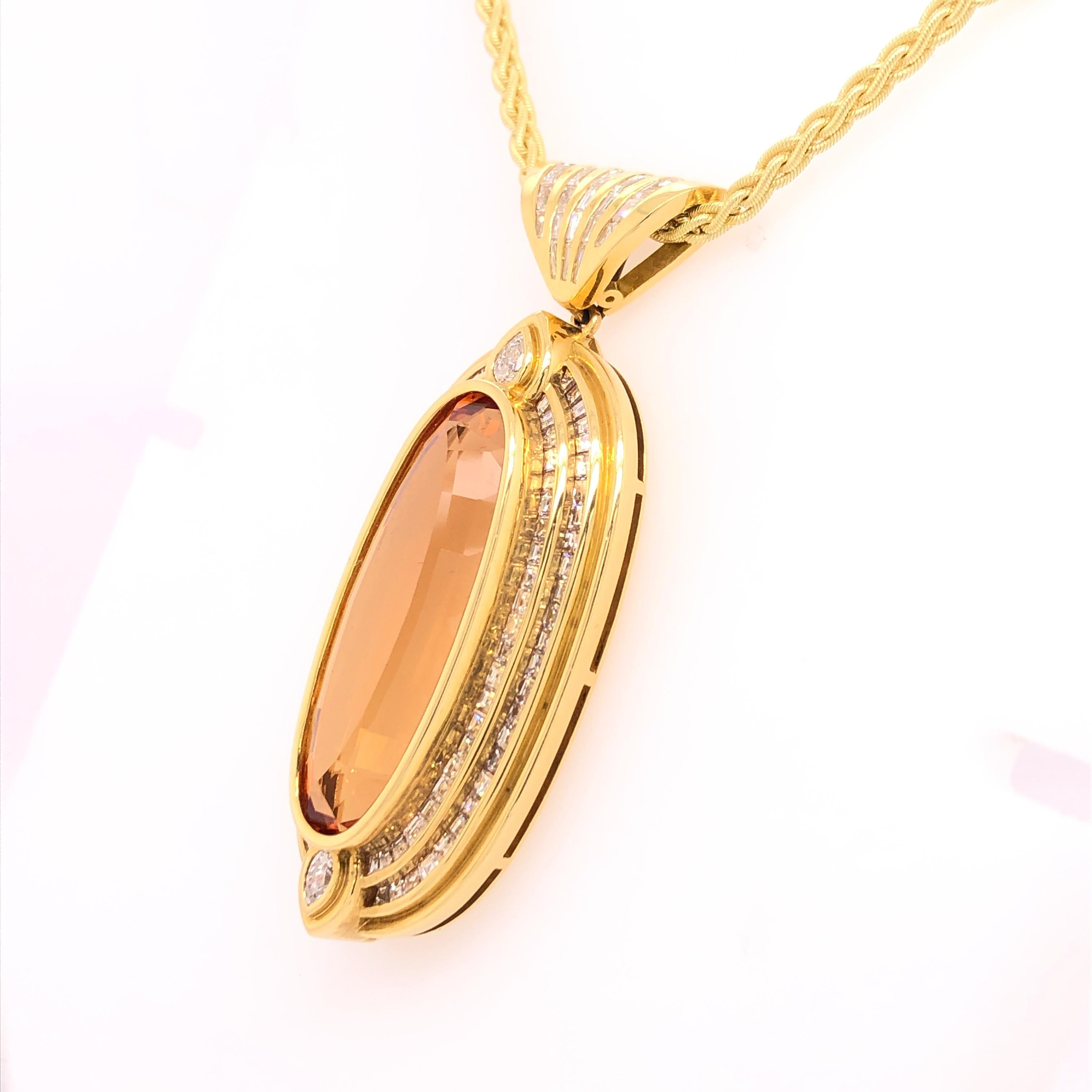 What strikes you first is the impressive size of the oval 42 carat Imperial Topaz that sits front and center in the 18K yellow gold pendant. Two rows of princess cut channel set diamonds surround the topaz giving it an even grander appearance. Two