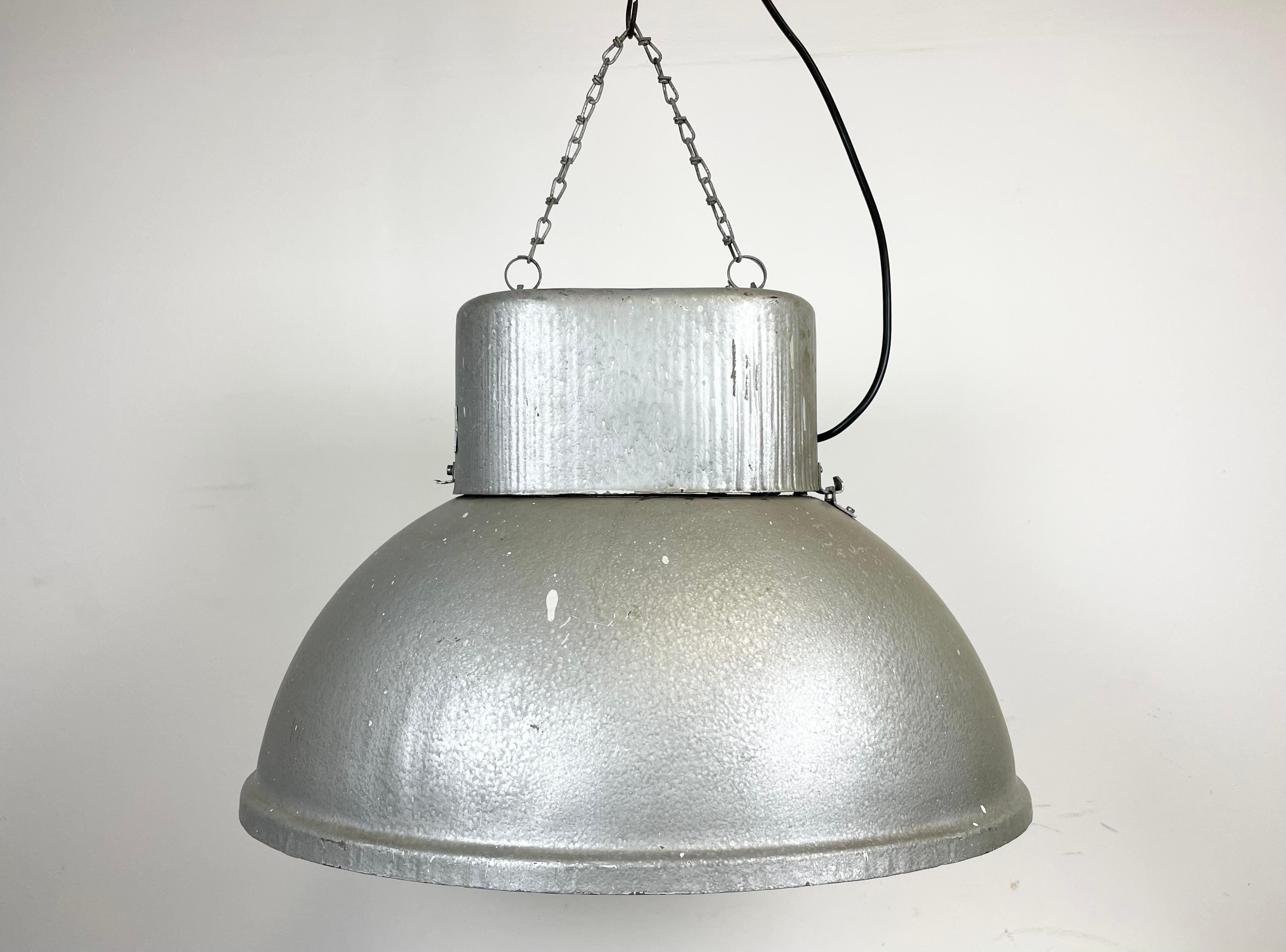 Vintage industrial hanging lamp manufactured in 1970s by Predom Mesko in Skarzysko-Kamienna in Poland. It features a hammerpaint iron body. The original porcelain socket E 40 is equipped with an adapter from E40 to E27 and requires E 27/ E 26 light