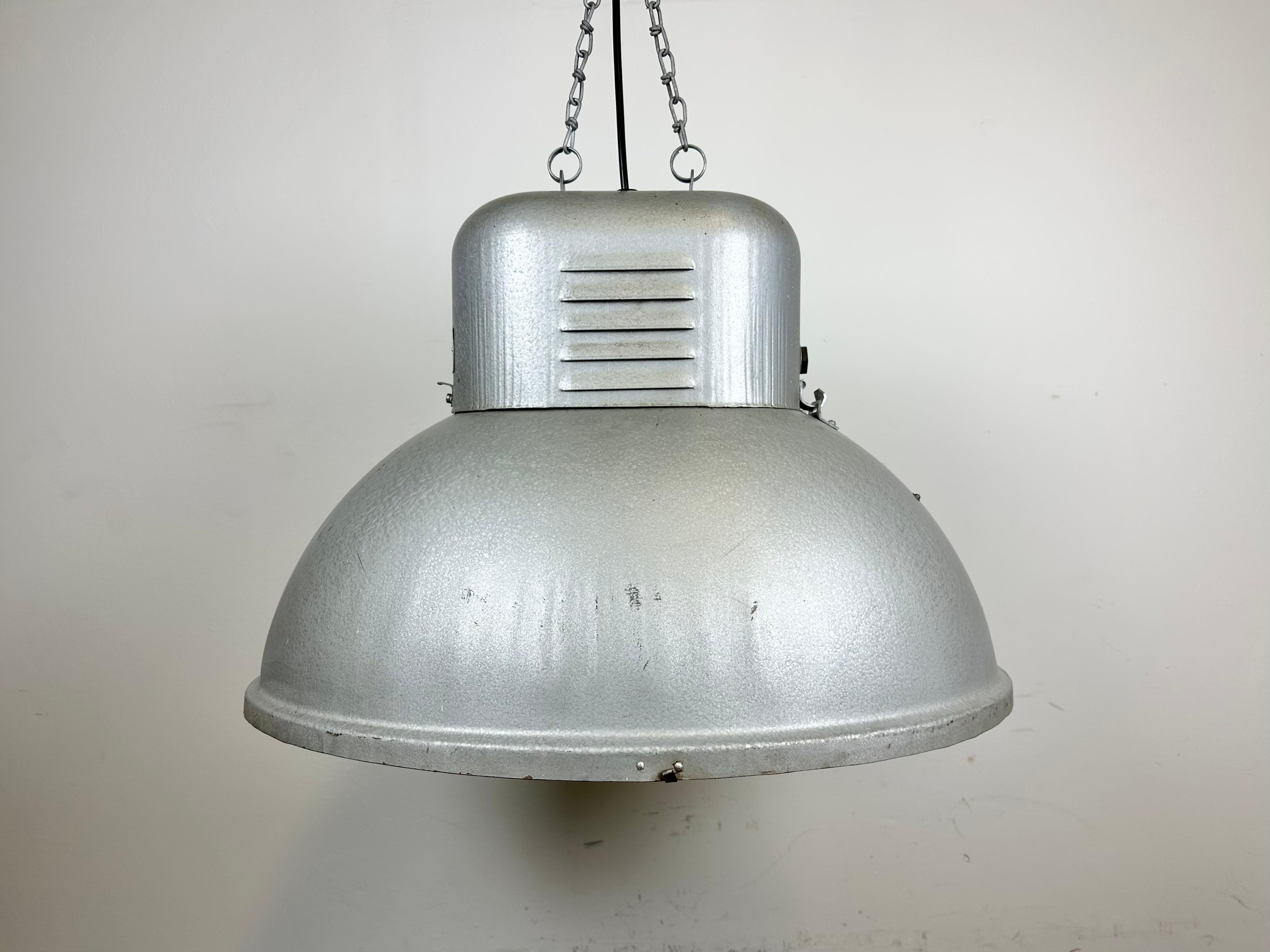 Vintage industrial hanging lamp manufactured in 1960s by Predom Mesko in Skarzysko-Kamienna in Poland. It features a hammerpaint iron body. The original porcelain socket E 40 is equipped with an adapter from E40 to E27 and requires E 27/ E 26 light