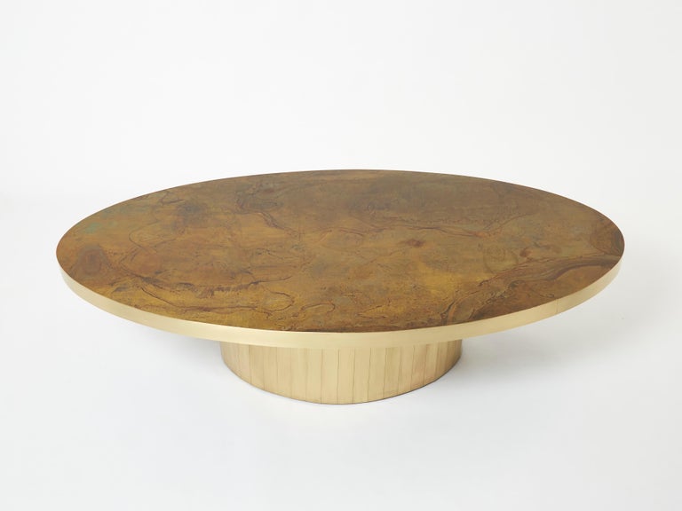 This unique large oval shaped coffee table was created by Isabelle and Richard Faure for Parisian design firm Maison Honore in the late 1970s. Entirely covered by decorated oxidized and patinated brass all over the top, that was then fixed and
