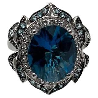 Anillo de oro blanco de 14 quilates con halo de diamantes y topacio azul de Londres ovalado grande