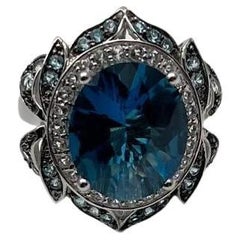 Anillo de oro blanco de 14 quilates con halo de diamantes y topacio azul de Londres ovalado grande