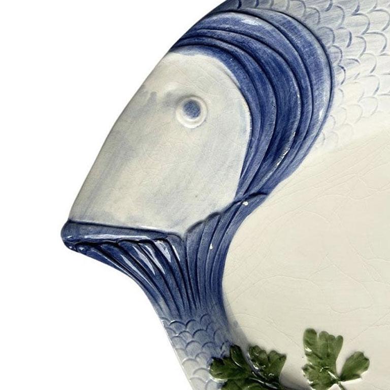 A large oval ceramic fish motif serving platter in blue, green, and cream. This piece is stamped on the back, 