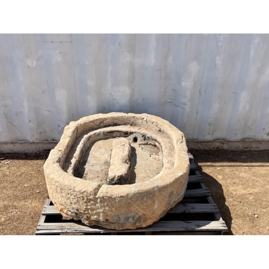 This is a unique millstone basin, with oval shape of varying levels and a drain hole. You can see the patina and wear from many years in use. The textural sides with some visible mortar that may be old repairs or just from adjacent mortar to the