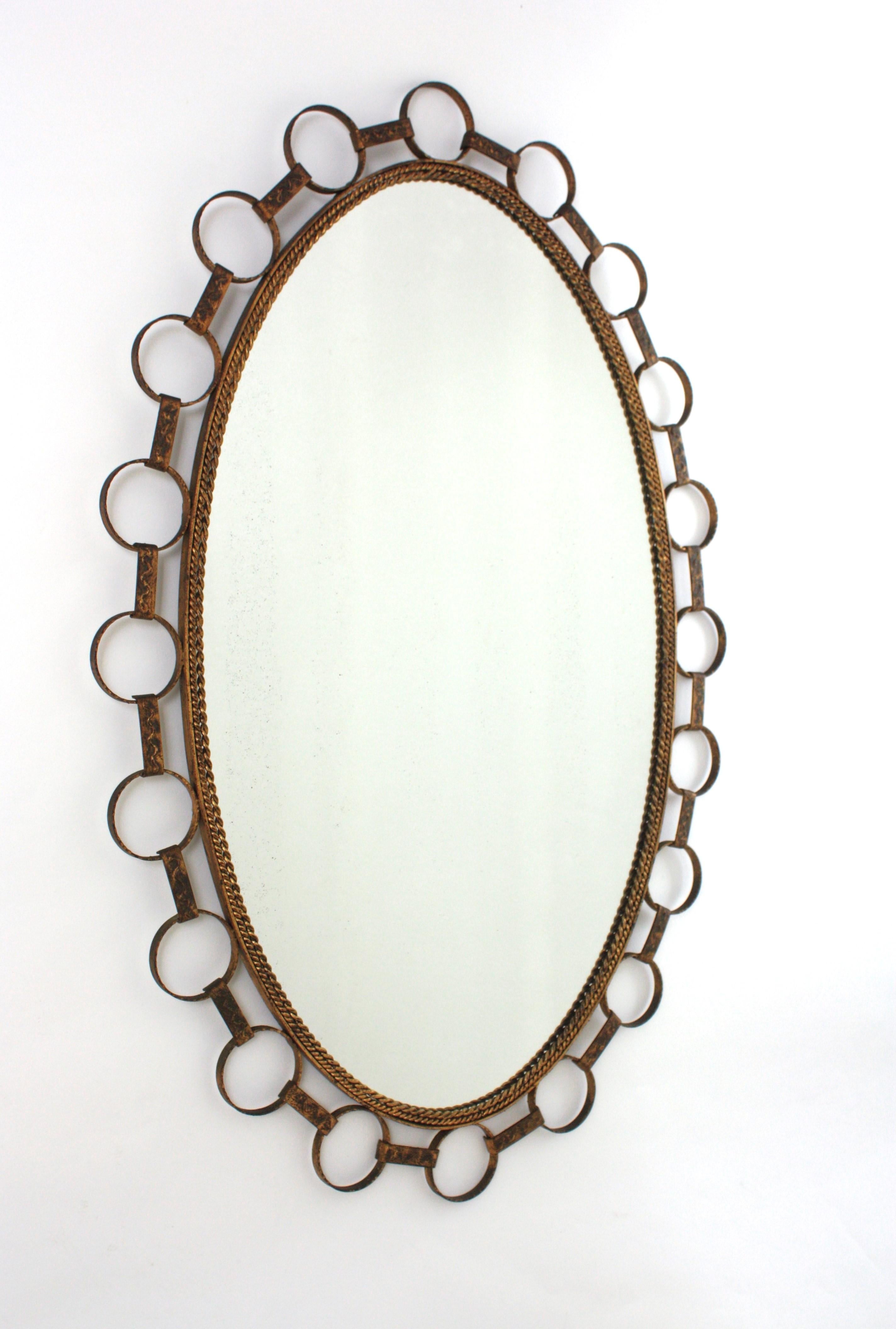 Mid-Century Modern Grand miroir ovale en fer doré avec cadre à anneaux, Espagne 1950 en vente