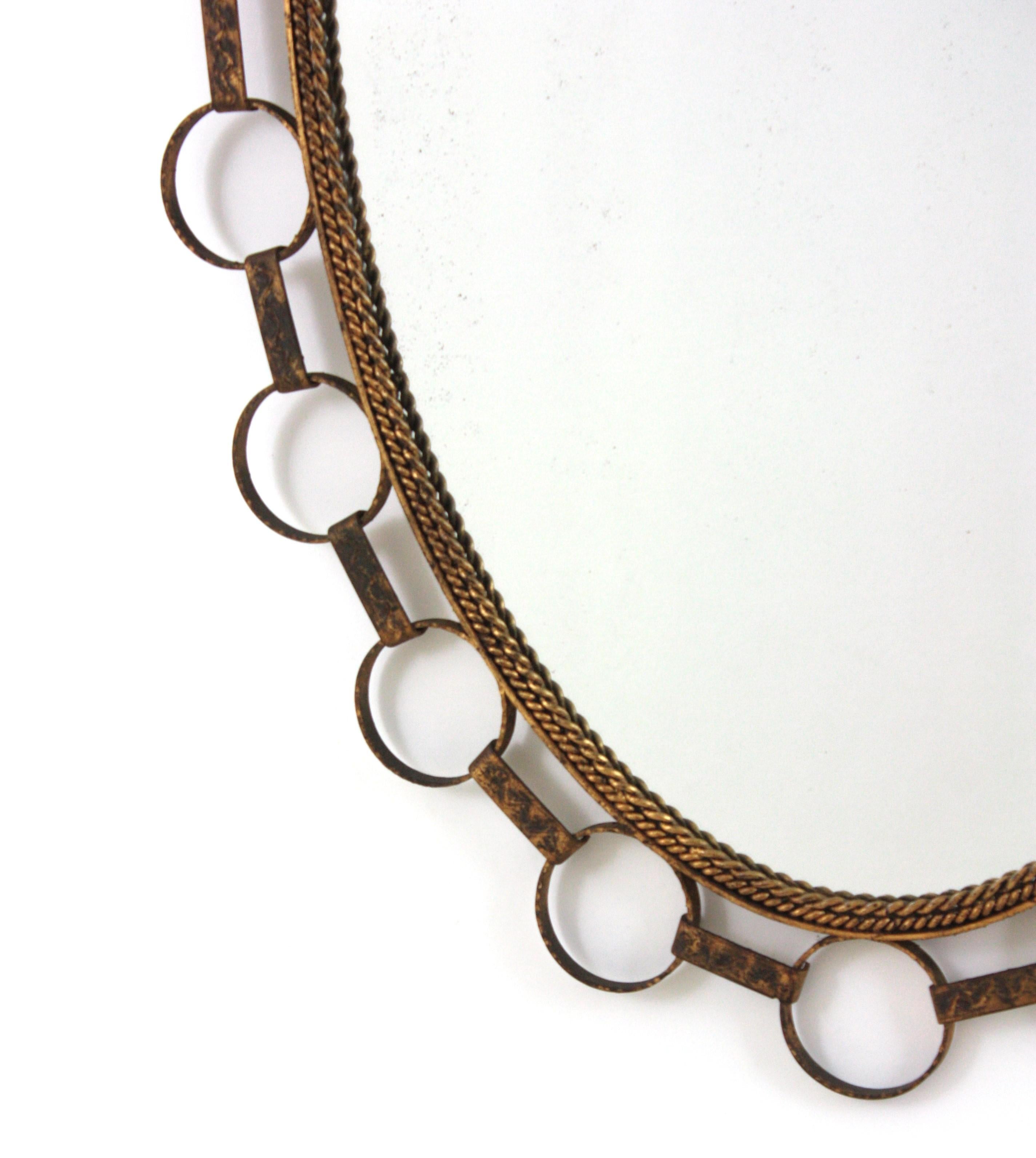 Miroir Grand miroir ovale en fer doré avec cadre à anneaux, Espagne 1950 en vente